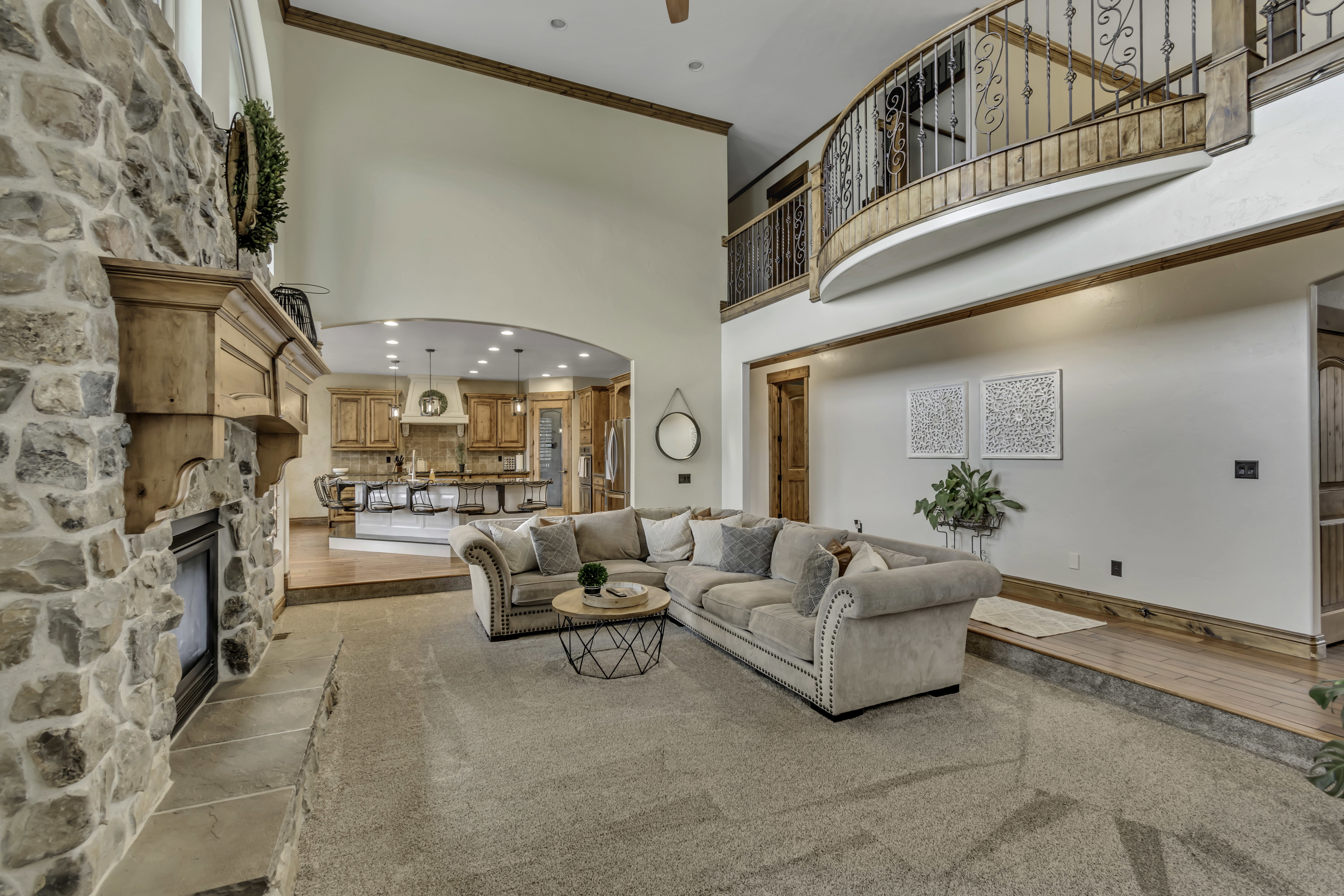 Grand living area featuring a stone fireplace with a wood mantel