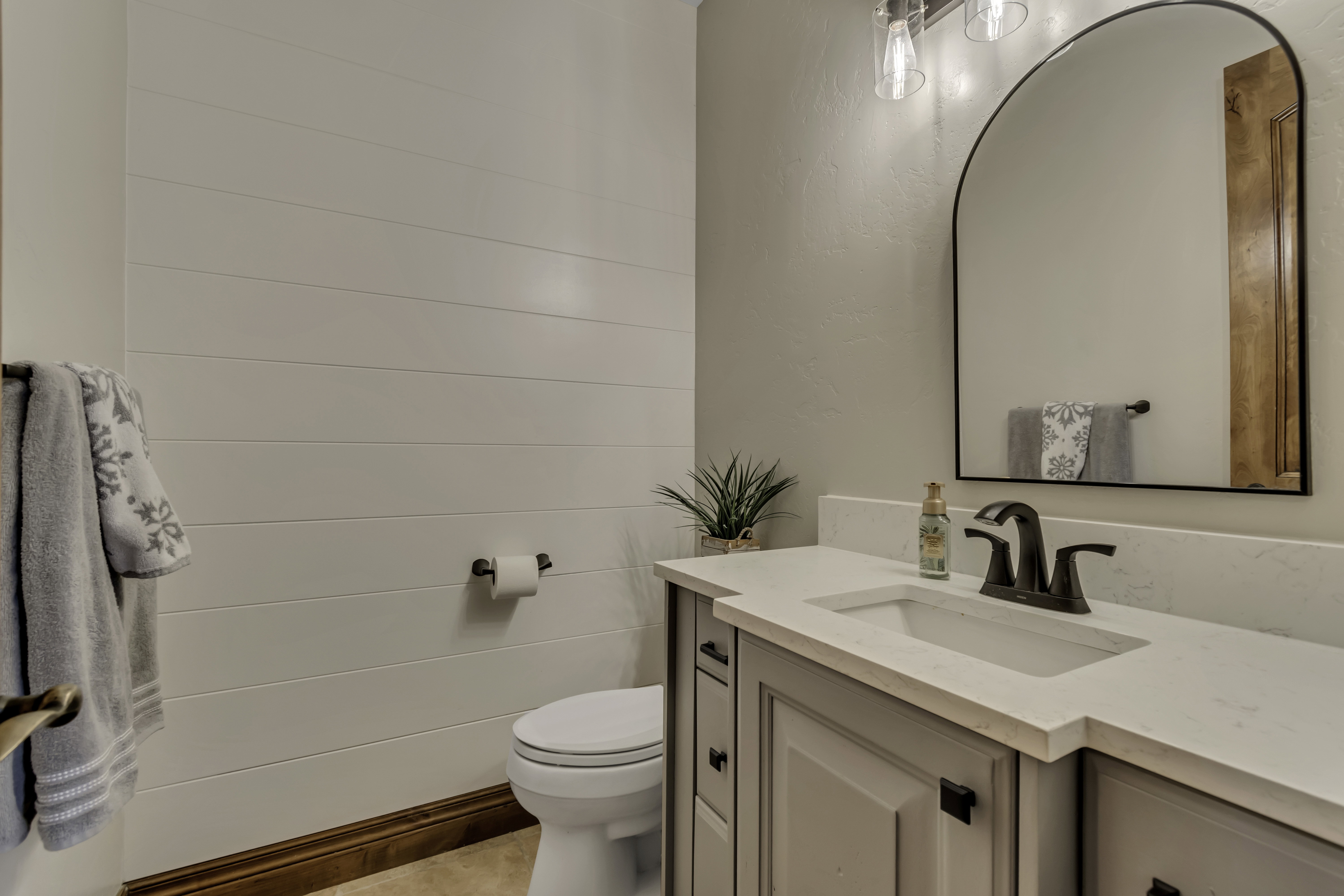 Bathroom vanity featuring a light gray cabinet with dark hardware, an integrated sink, and a white countertop