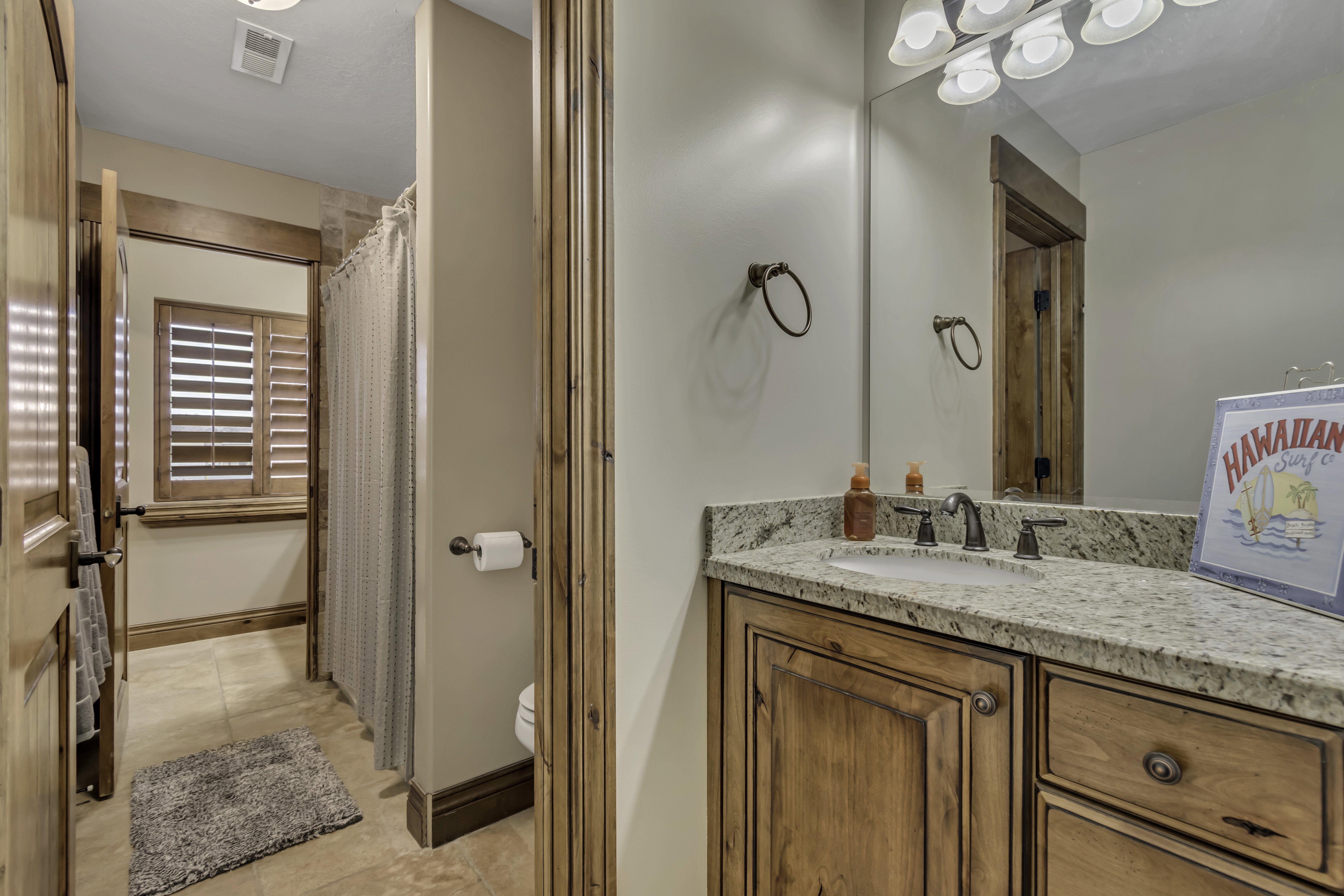 Full bathroom featuring a single vanity with stone countertop, integrated sink, and wood cabinetry