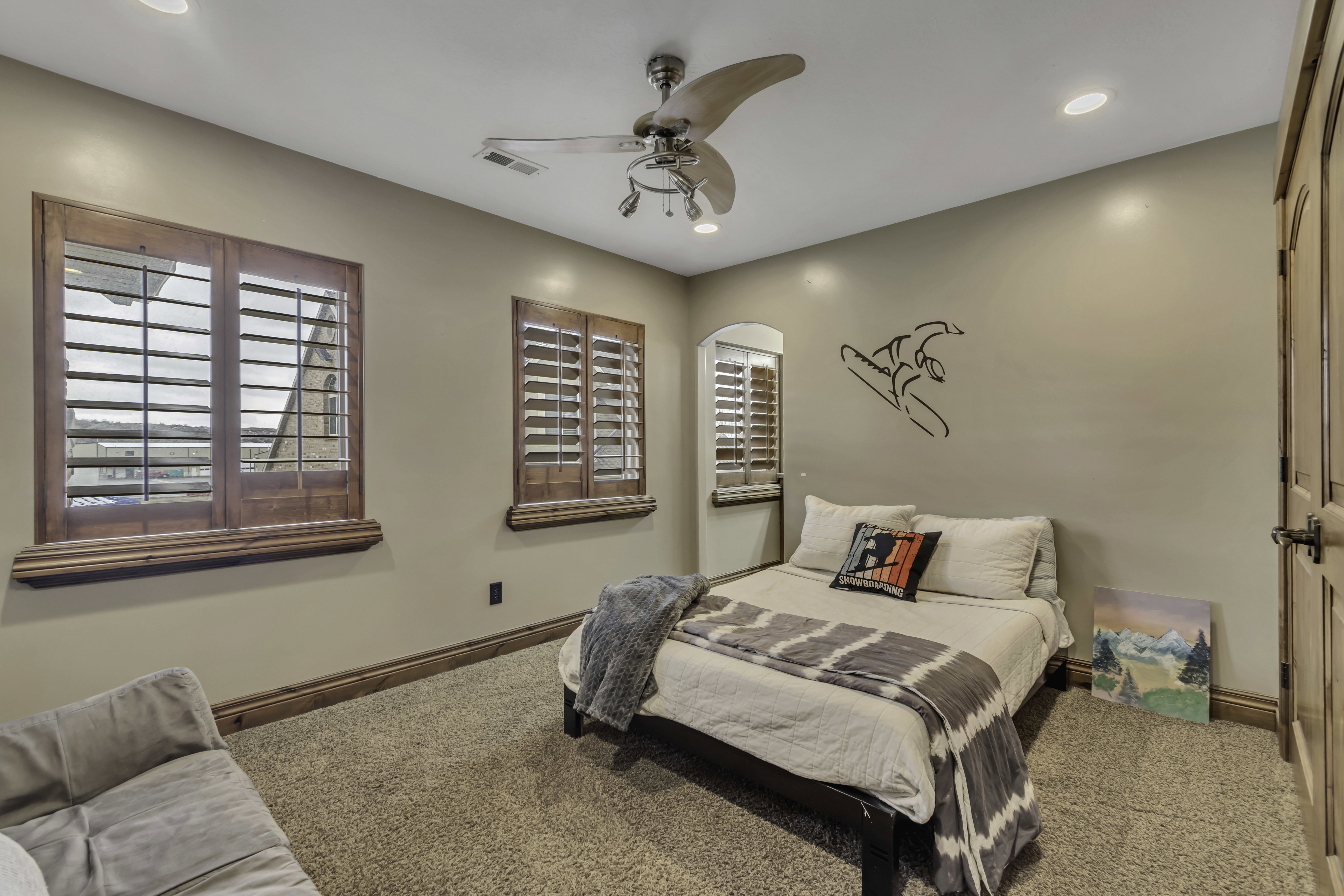 Carpeted room featuring two windows with wood plantation shutters, recessed lighting, and a ceiling fan