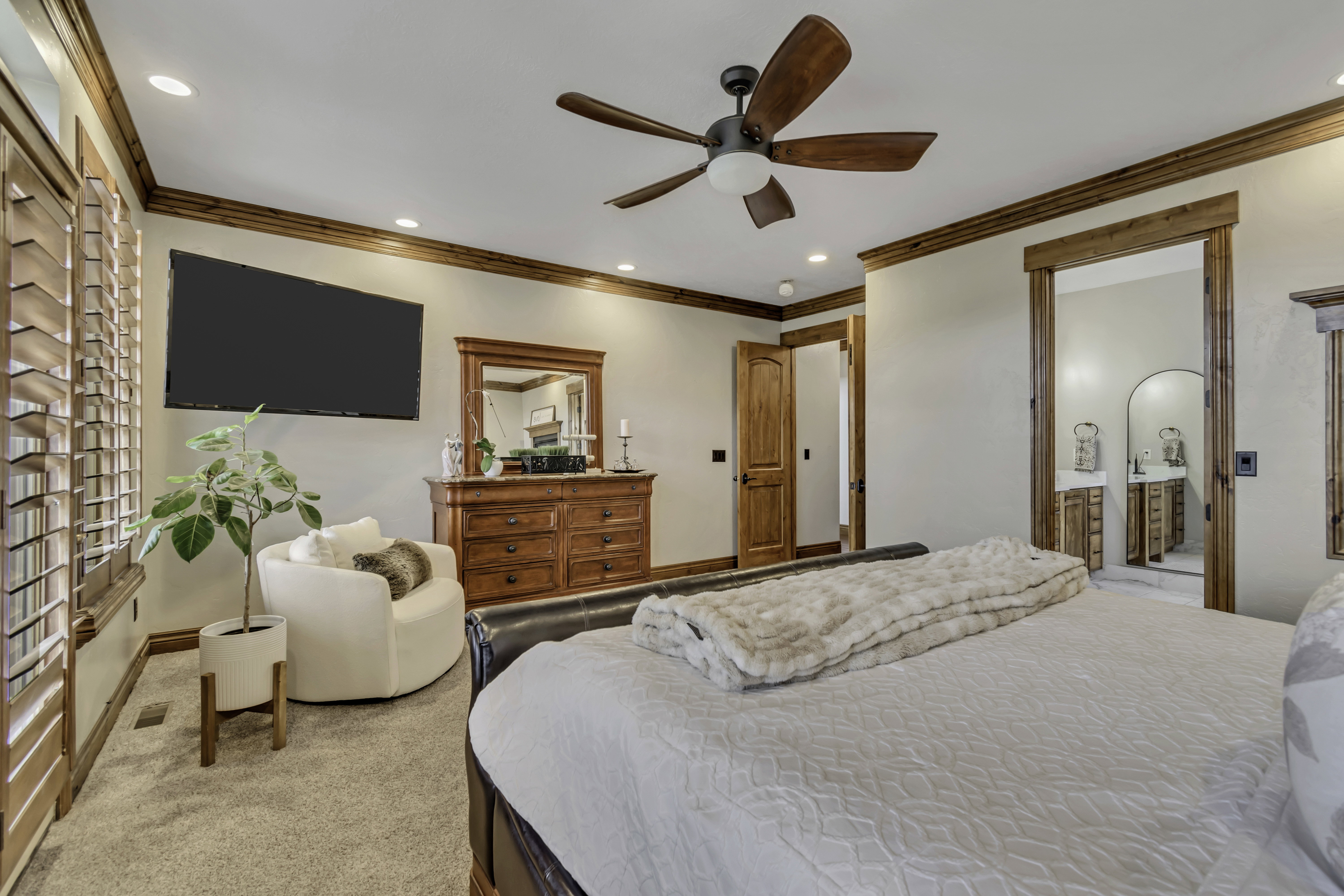 Carpeted room featuring wood-finish crown molding and trim, recessed lighting, and a dark wood-finish ceiling fan