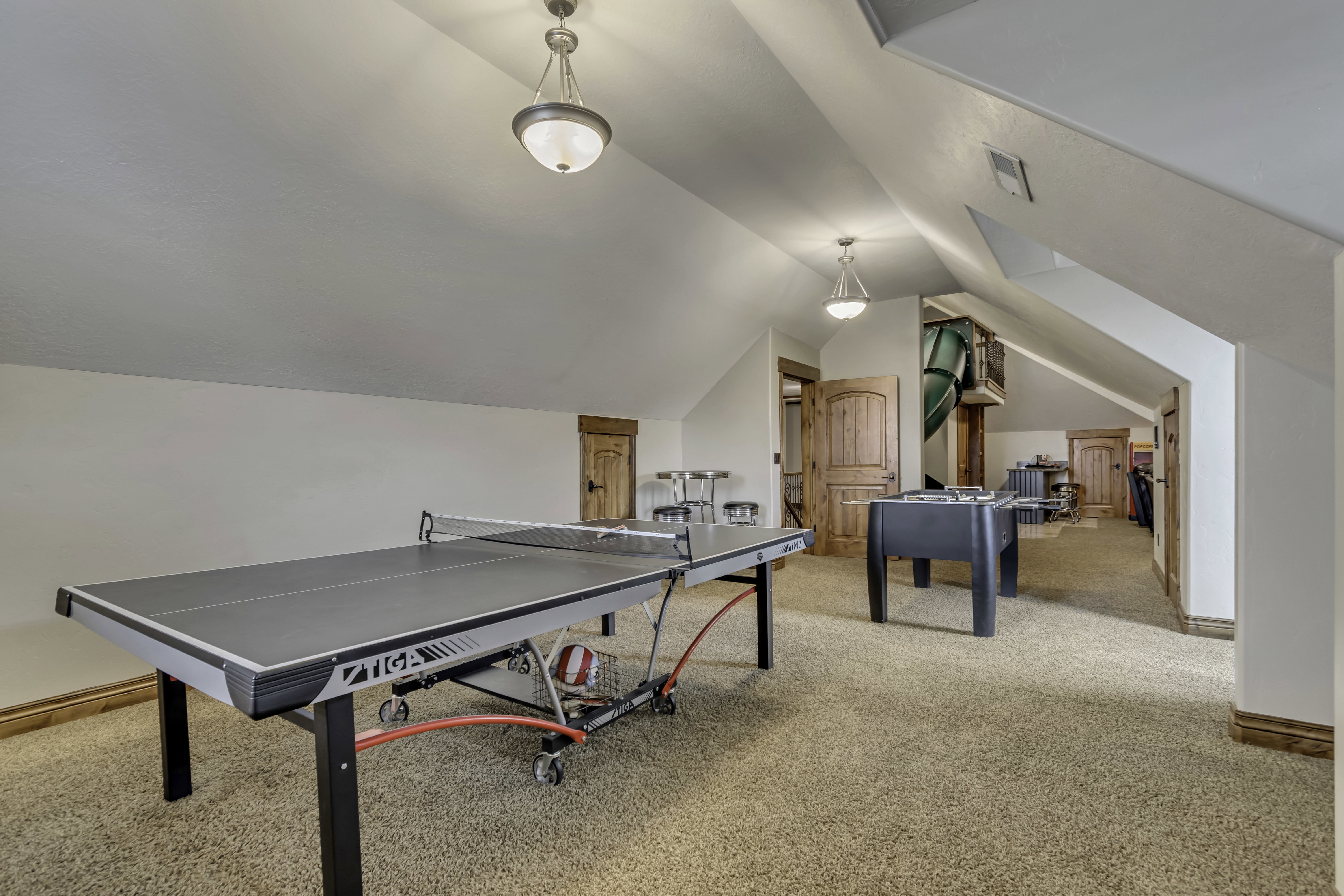 Carpeted loft area featuring a vaulted ceiling and recessed lighting