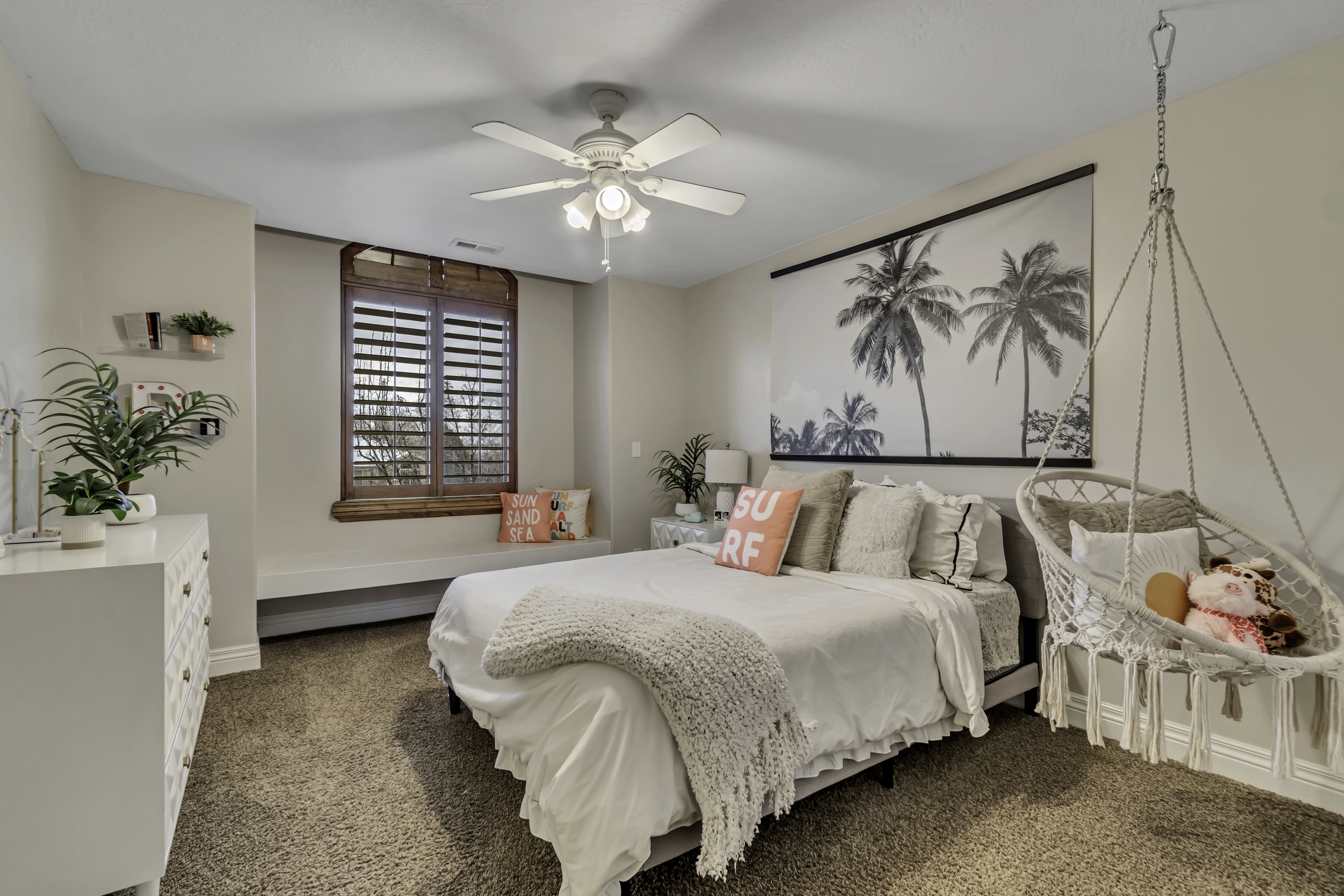 Bedroom featuring a built-in window seat, wood plantation shutters, and carpet flooring