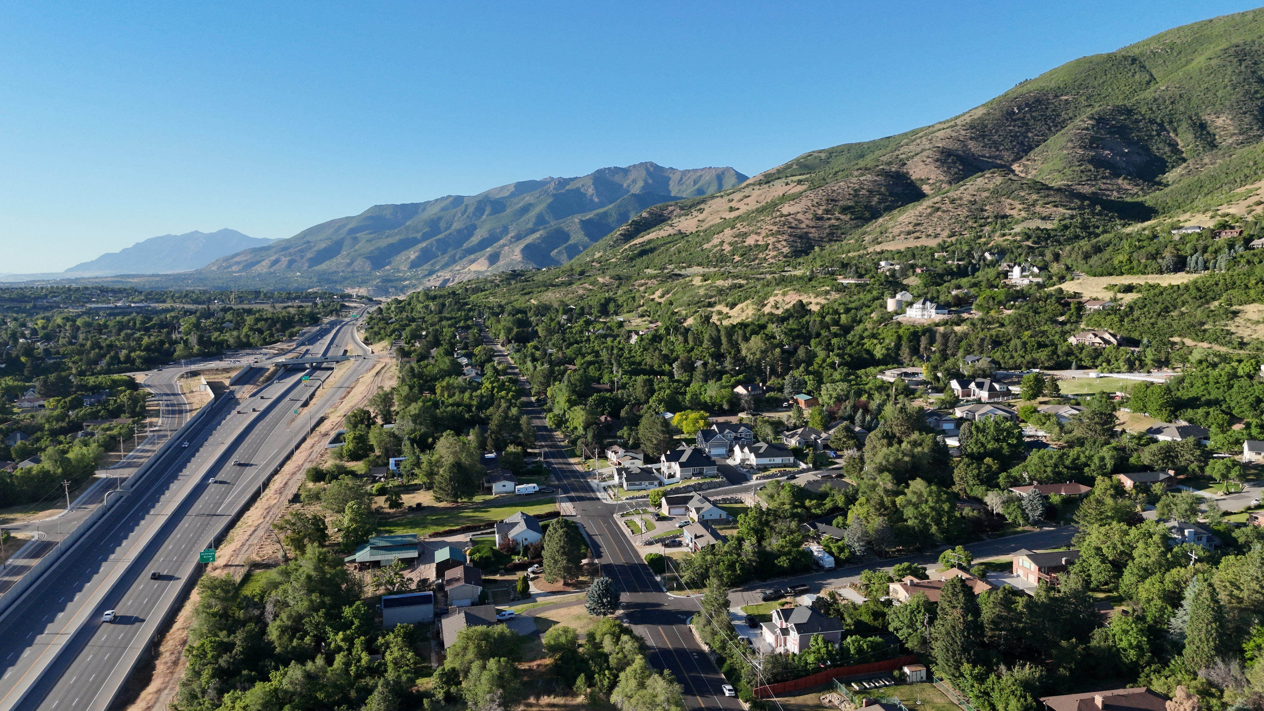 Mountainous terrain and lush green landscape frame the surrounding residential area