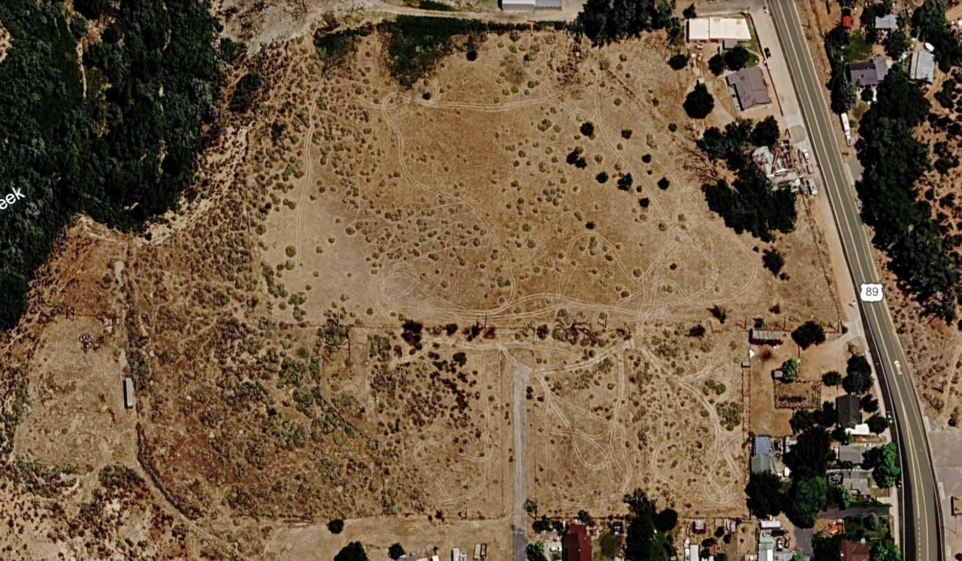 Expansive undeveloped land featuring natural vegetation and direct access to a main road