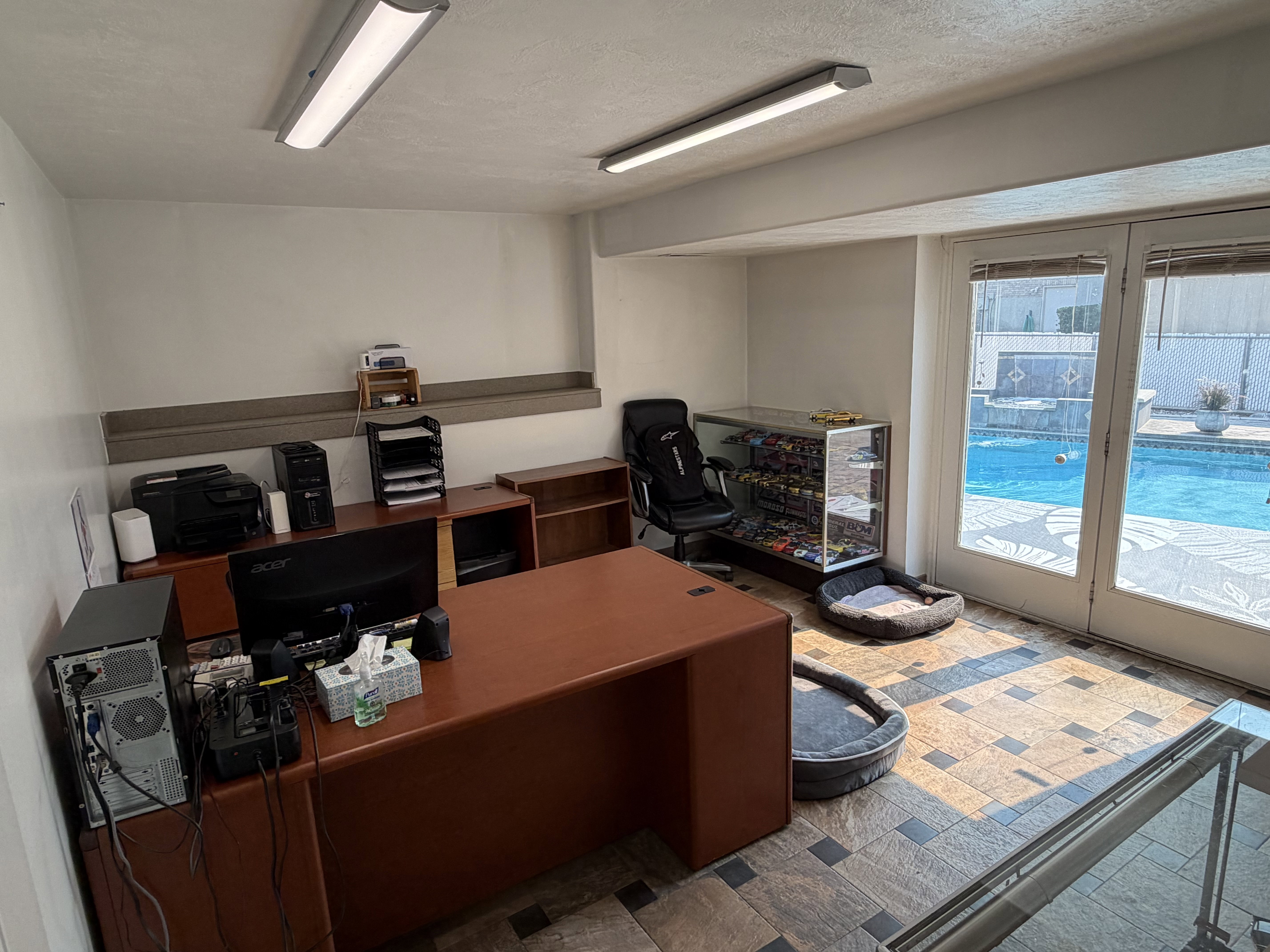 Room featuring tiled flooring, track lighting, and a built-in display case