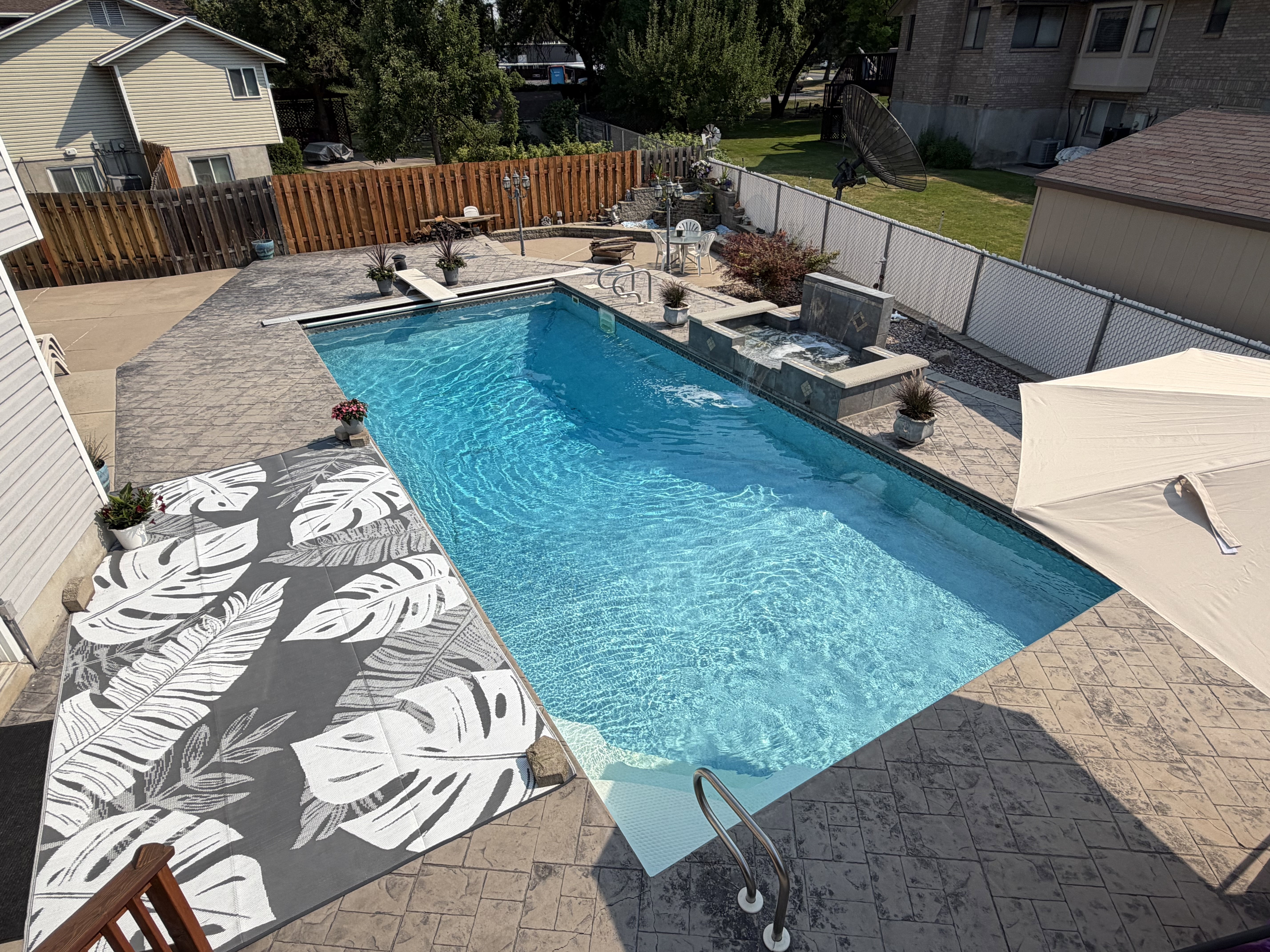 In-ground swimming pool with stamped concrete surround