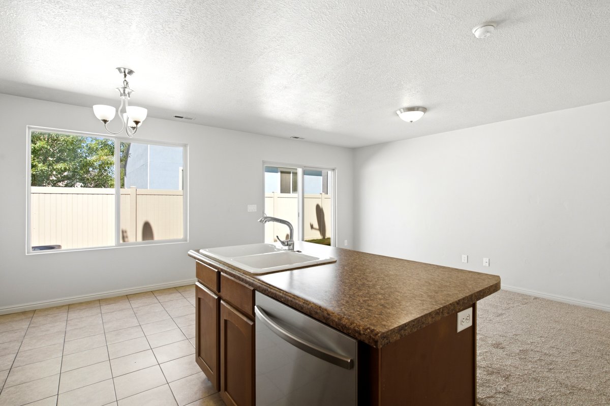 Kitchen island featuring a double basin sink and integrated dishwasher