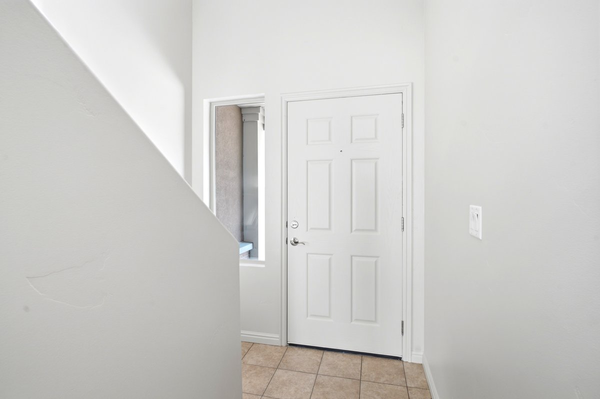 Entryway featuring a paneled door, a sidelight window, and tile flooring