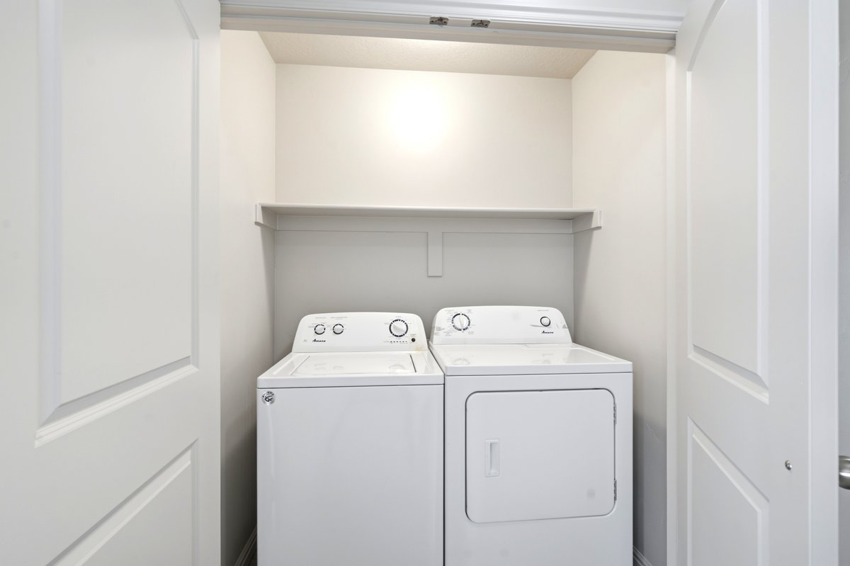 Dedicated laundry closet featuring a top-load washing machine and front-load dryer