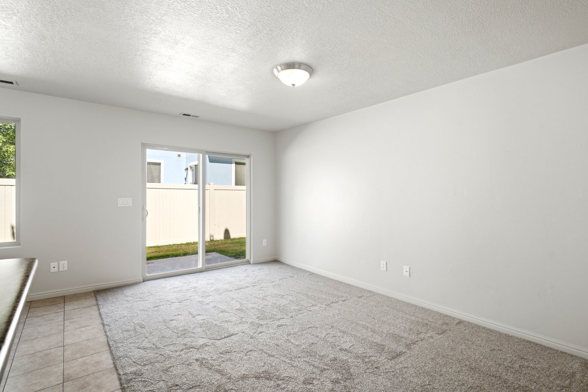 Spacious interior room featuring light-toned carpeting and neutral wall paint