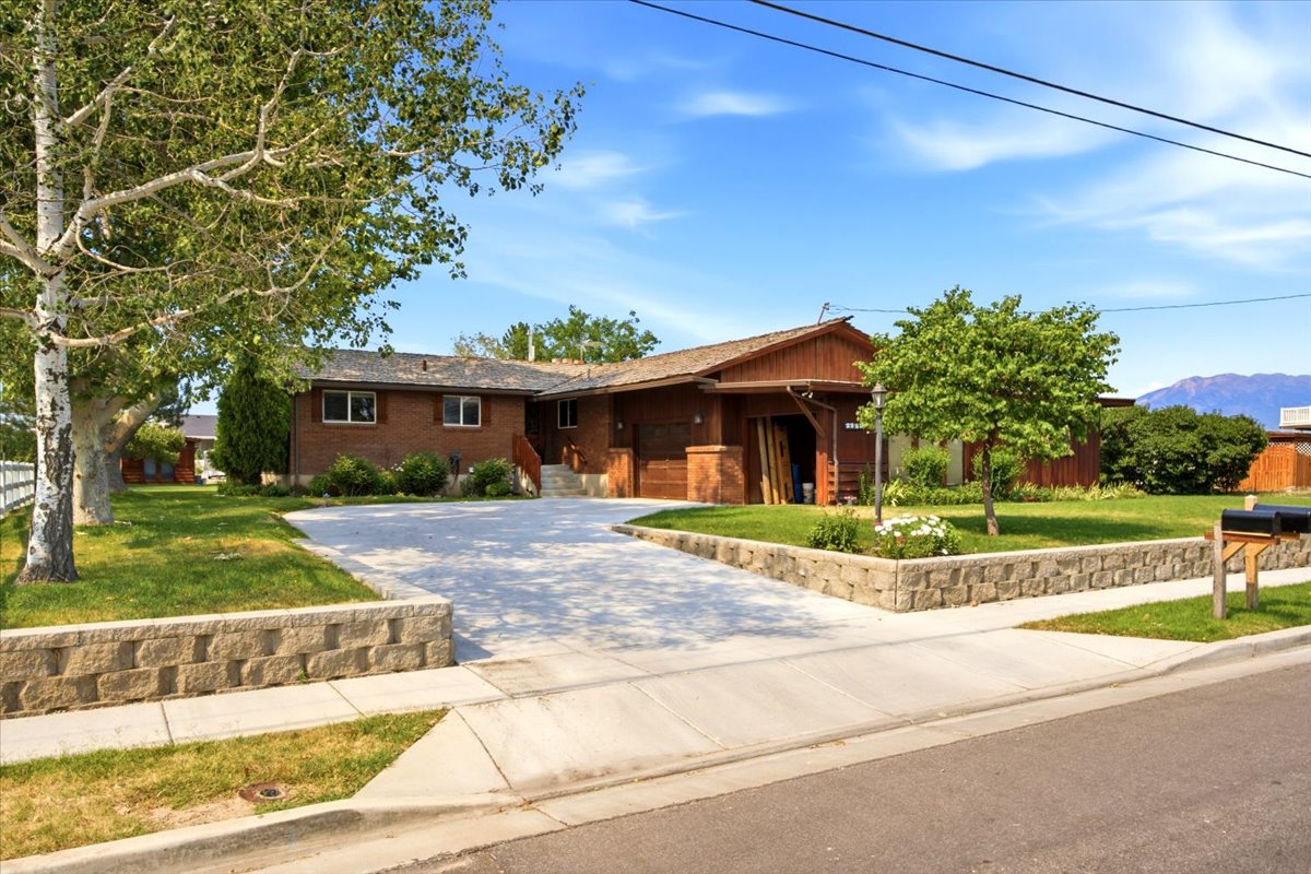 Brick and wood-sided residence featuring a multi-level design and an attached carport