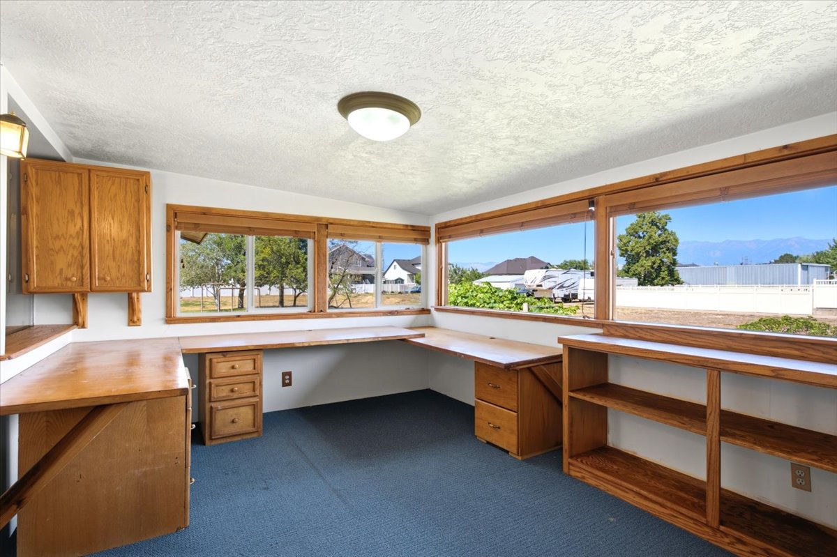 Room featuring built-in wood-finish cabinetry, integrated desk space, and expansive windows