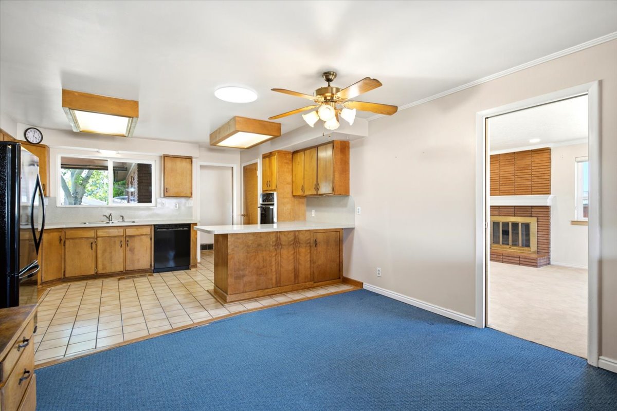 Eat-in kitchen featuring wood cabinetry, tile flooring, and a breakfast bar
