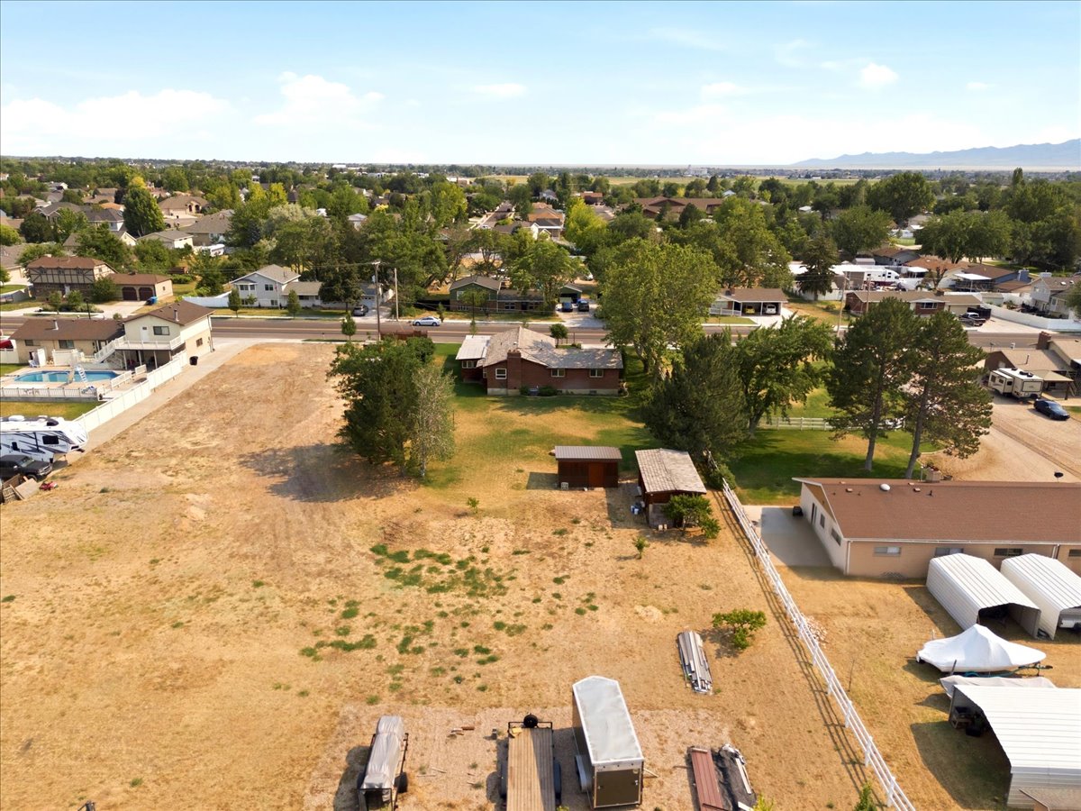 Expansive lot featuring a large, undeveloped parcel with partial fencing and established trees