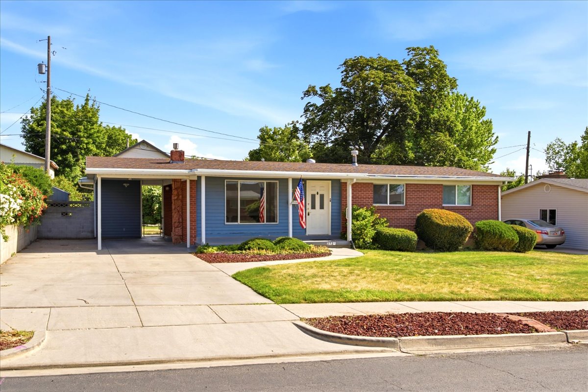 It's a Ranch-style home featuring a brick and siding exterior, an attached carport, and a concrete 2-car wide driveway