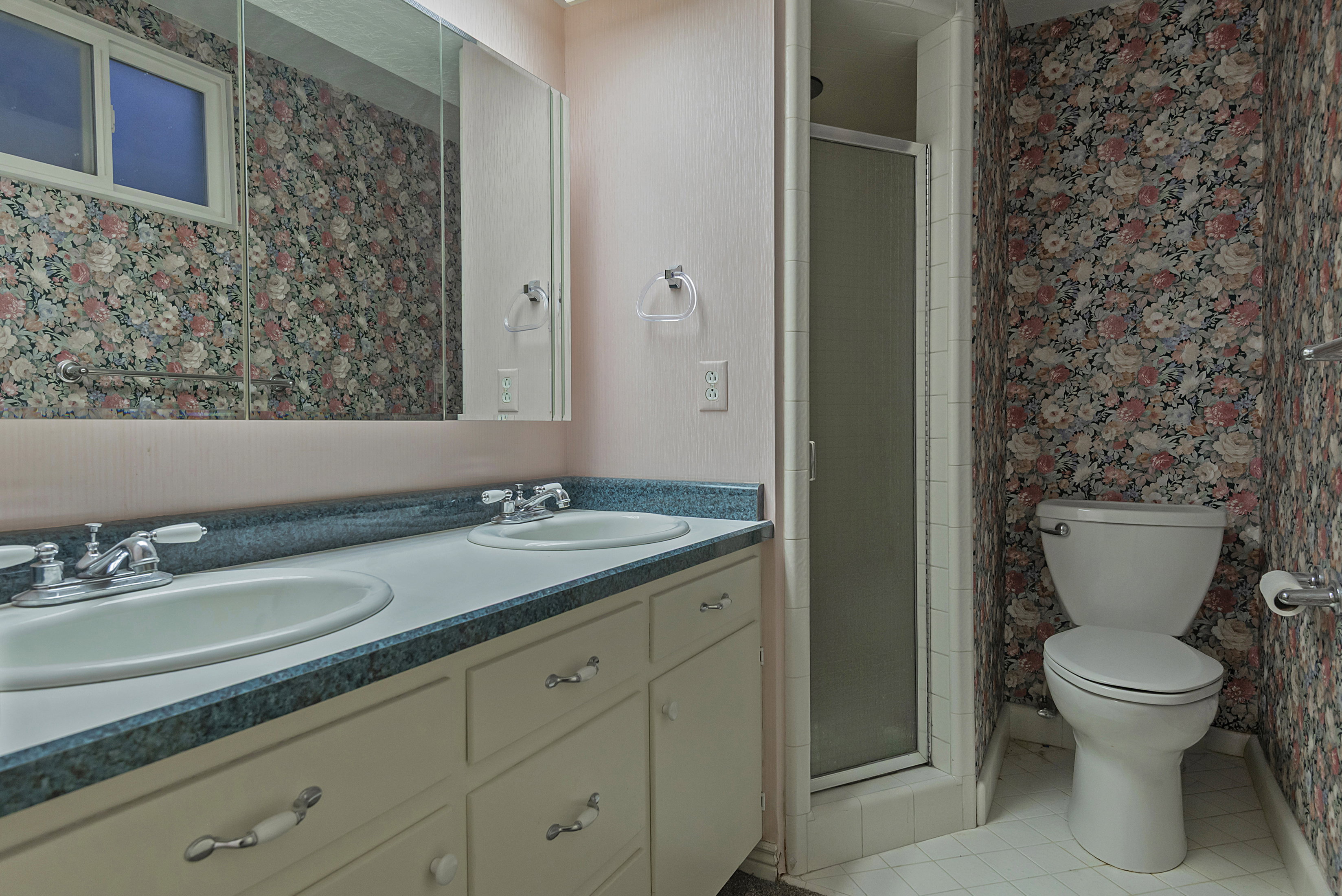 Bathroom featuring a double vanity with integrated sinks and a blue flecked countertop