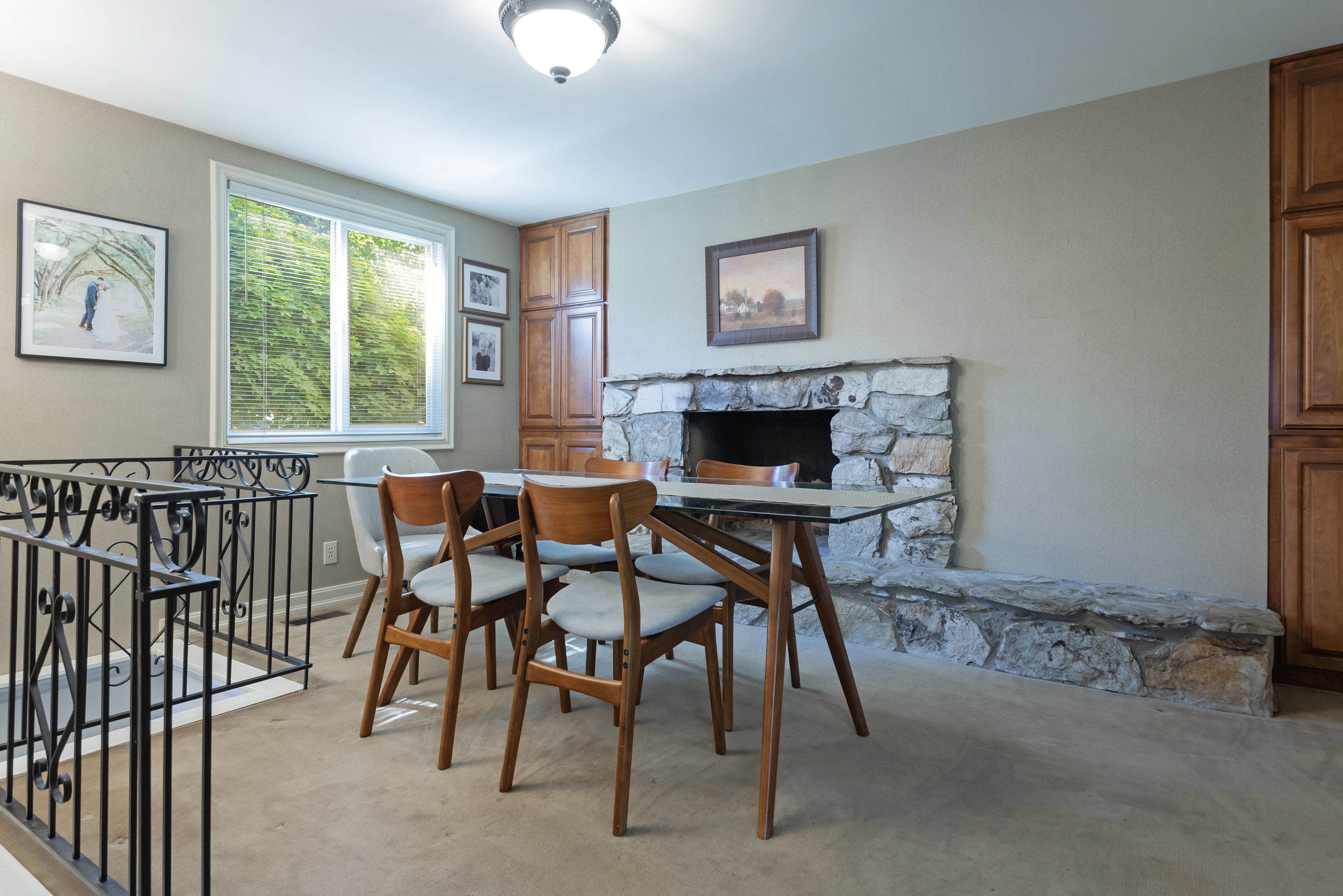 Stone fireplace with an extended hearth, complemented by built-in wood cabinetry