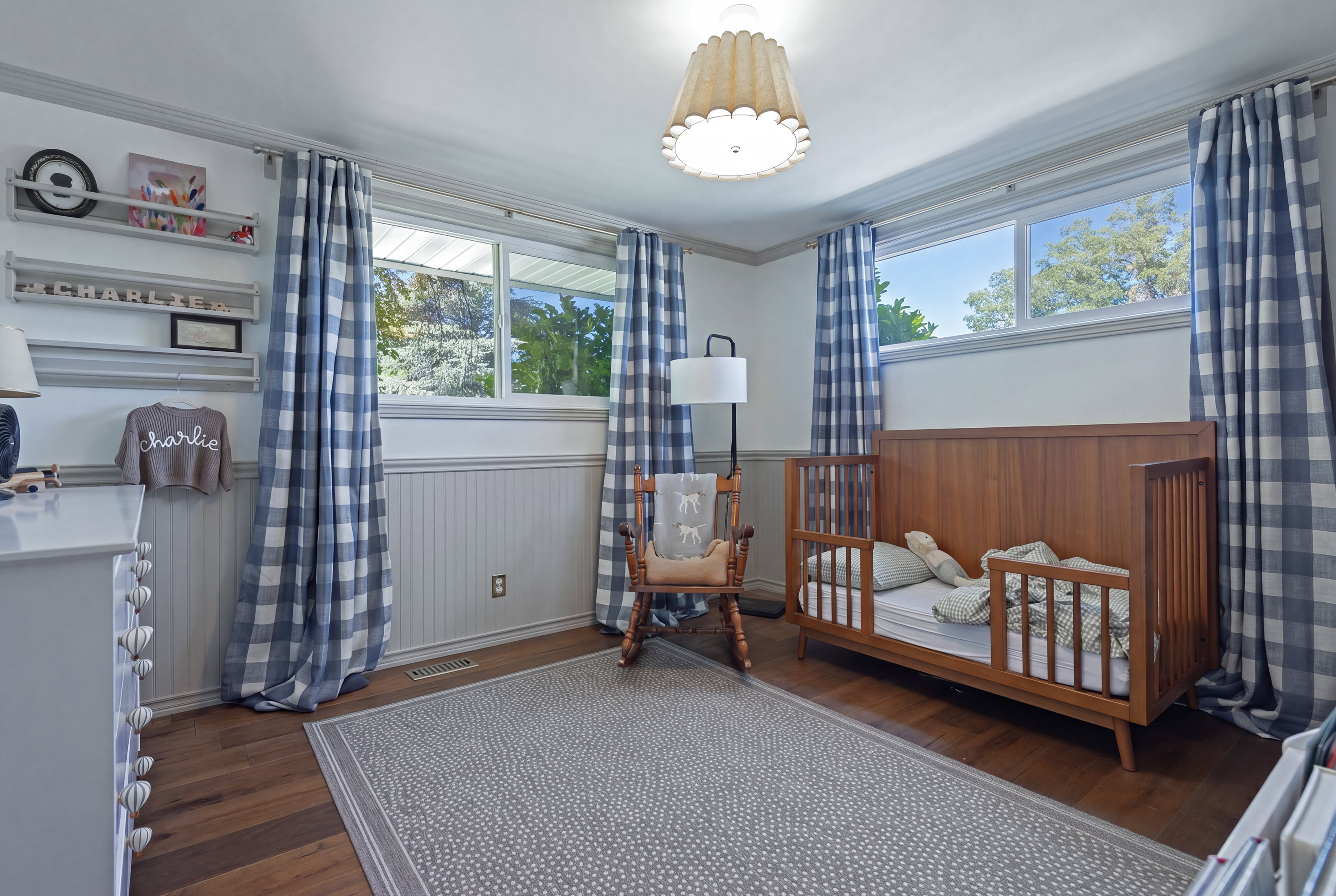 Room featuring wood-finish flooring, white beadboard wainscoting, and crown molding