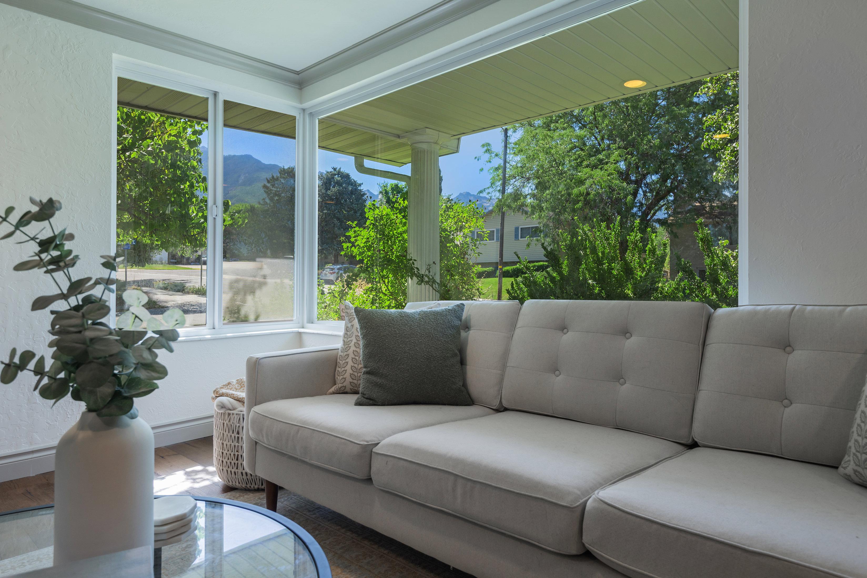 Bright interior space featuring a window wall, crown molding, and wood-finish flooring