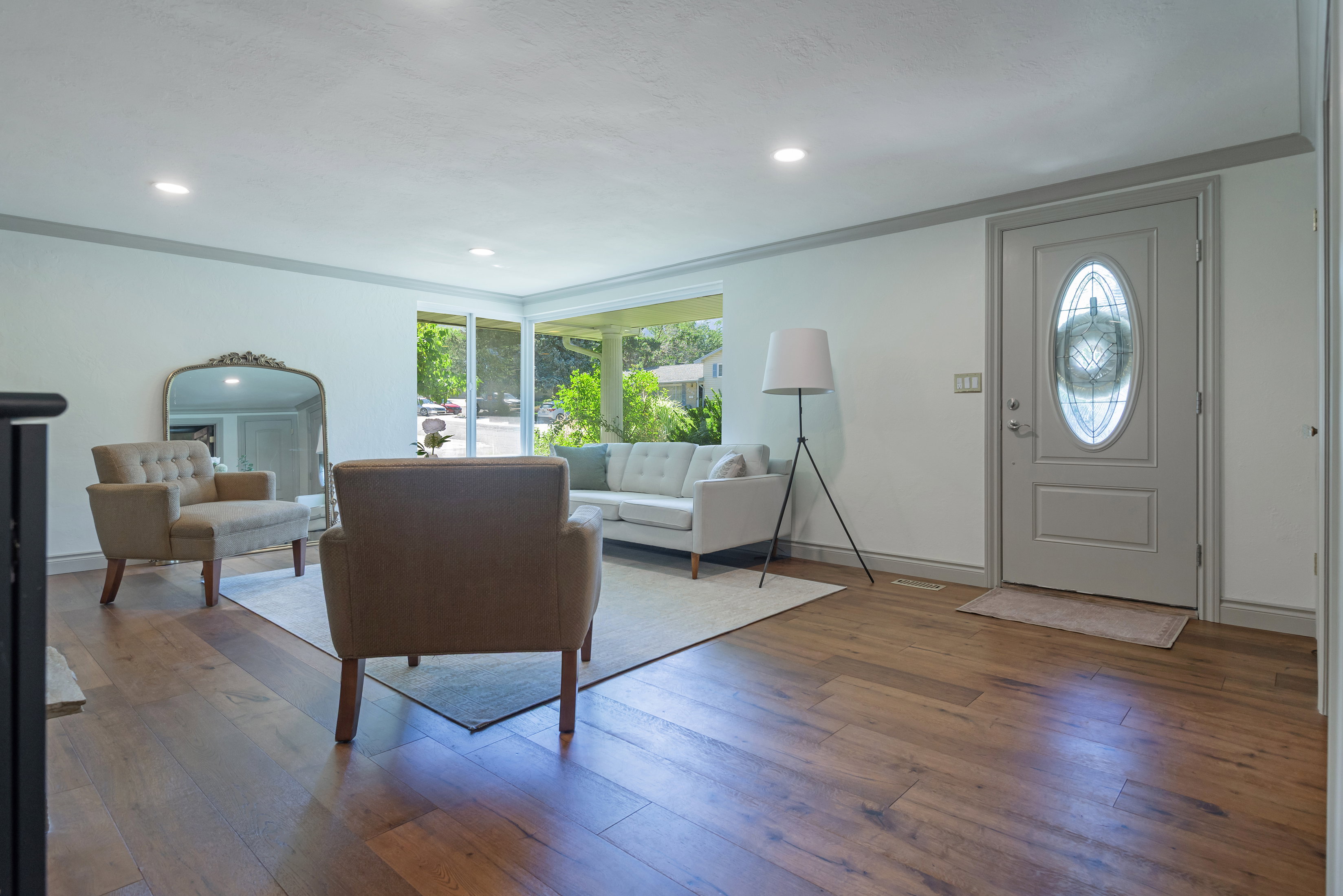 Open-concept living space with wood-finish flooring, recessed lighting, and large windows