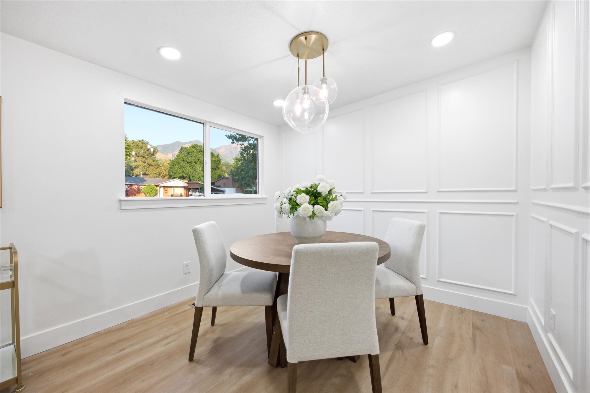 Dining area featuring wood-finish flooring, recessed ceiling lighting, and a contemporary chandelier
