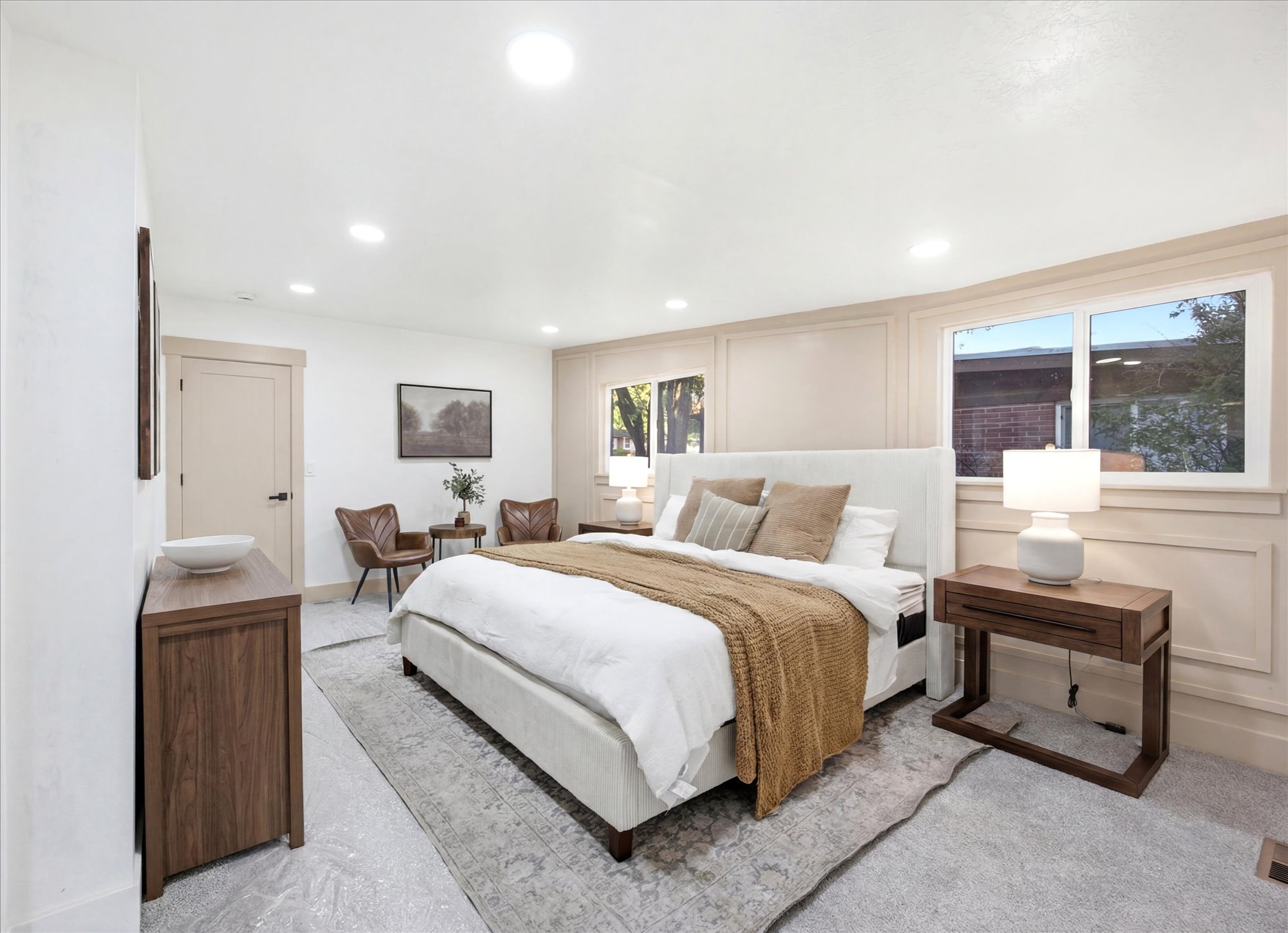 Spacious bedroom with light gray carpet flooring and recessed ceiling lighting