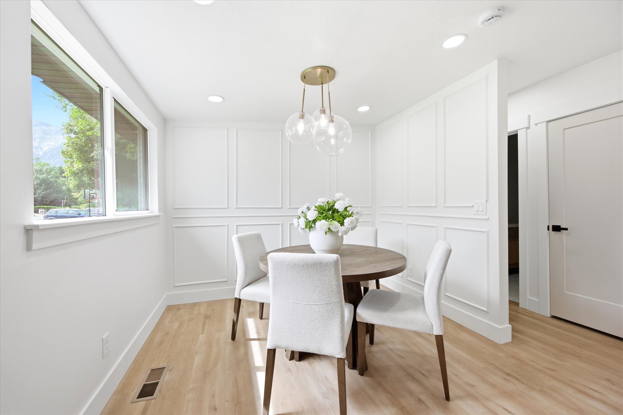 Dining area featuring wainscoting paneling, wood-finish flooring, and recessed lighting