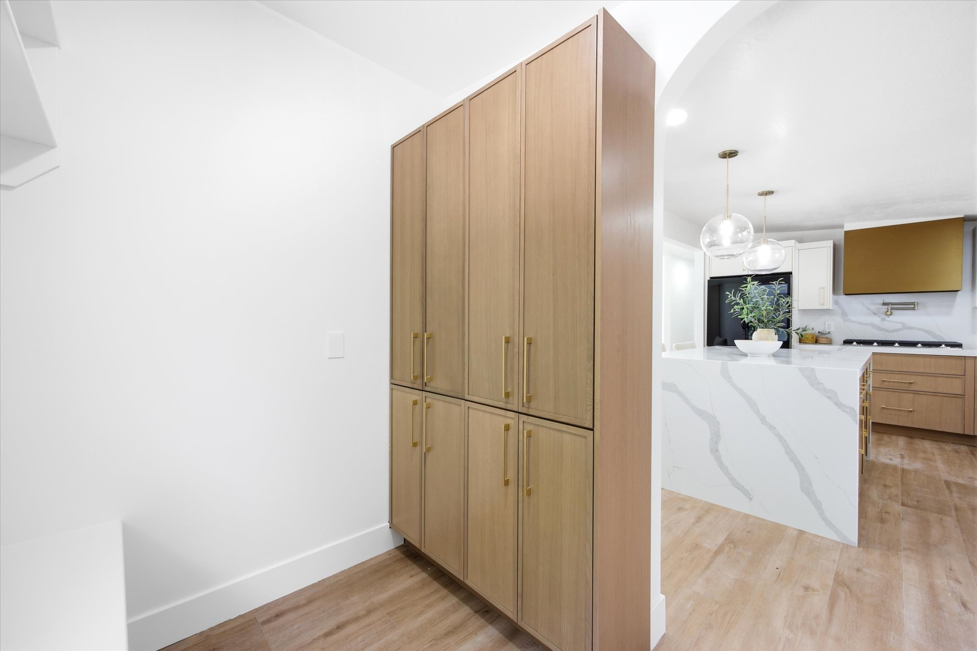 Floor-to-ceiling cabinetry with brass hardware providing ample storage