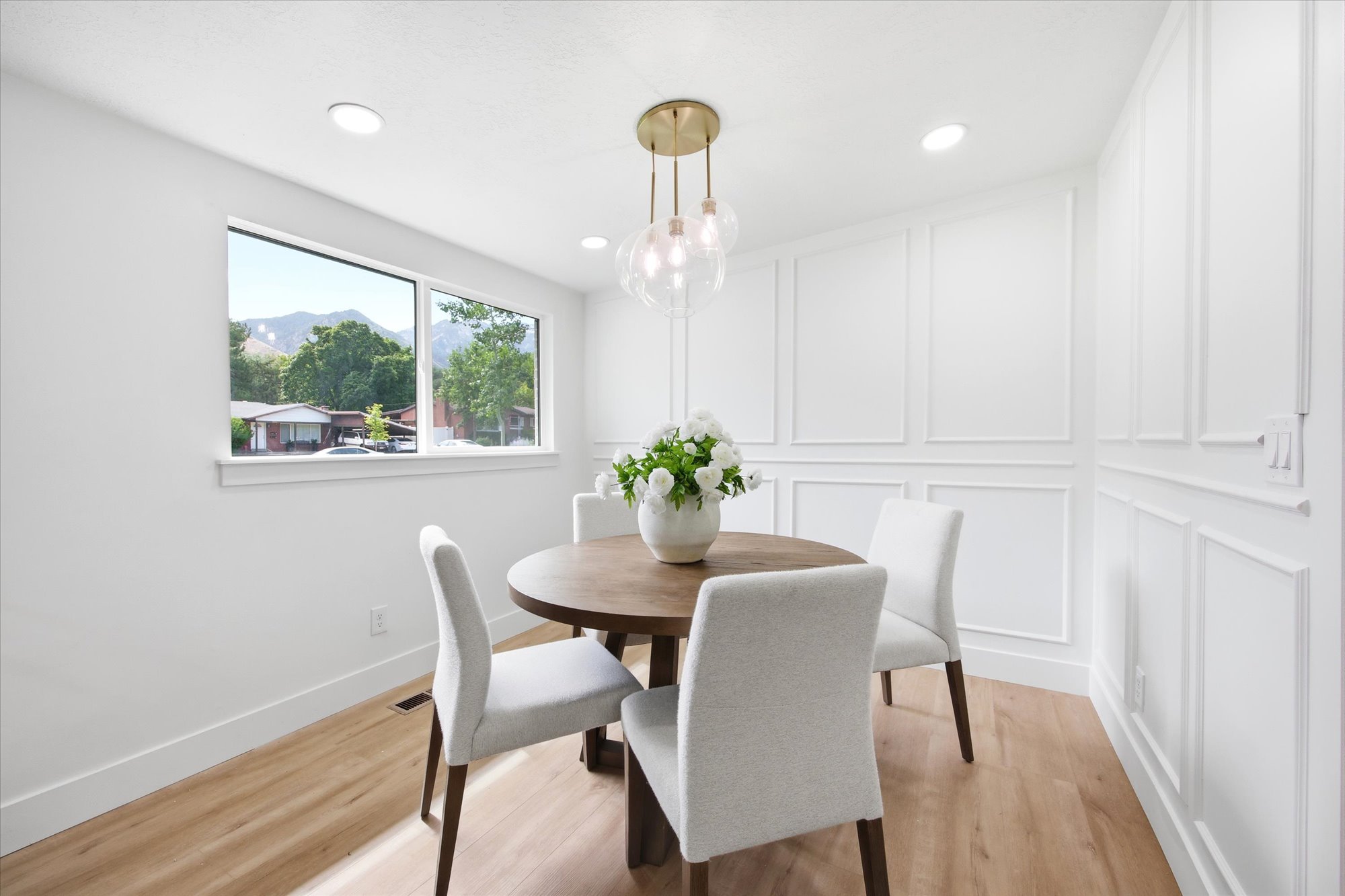 Bright dining space featuring wood-finish flooring, recessed lighting, and decorative wall molding
