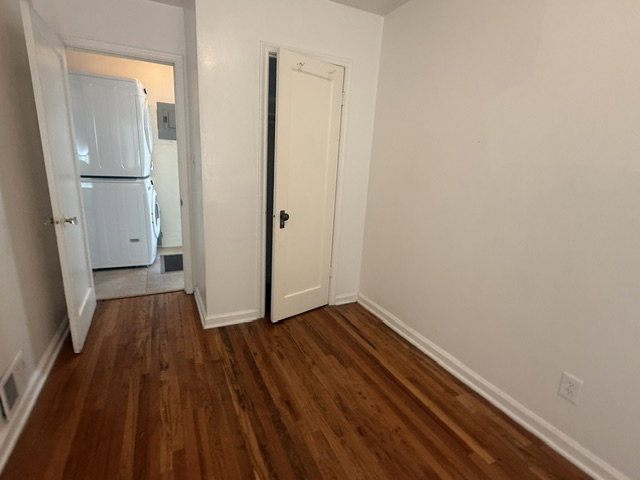 Hardwood flooring extends throughout this room, with white baseboards and neutral wall finishes