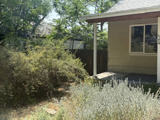 Single-story residence featuring light-colored siding, a covered porch entry, and a white-trimmed window