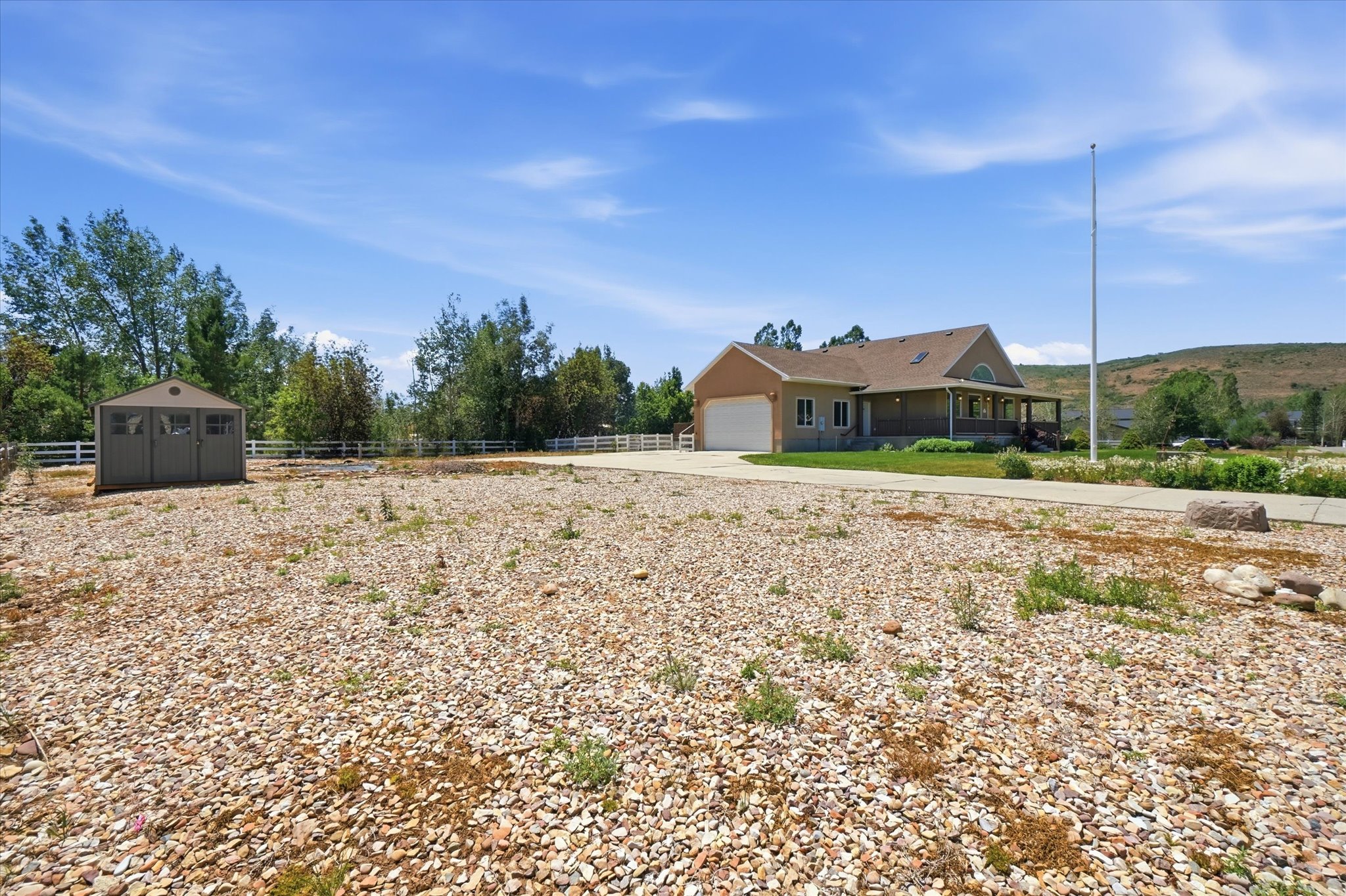 Expansive gravel foreground with a detached storage shed