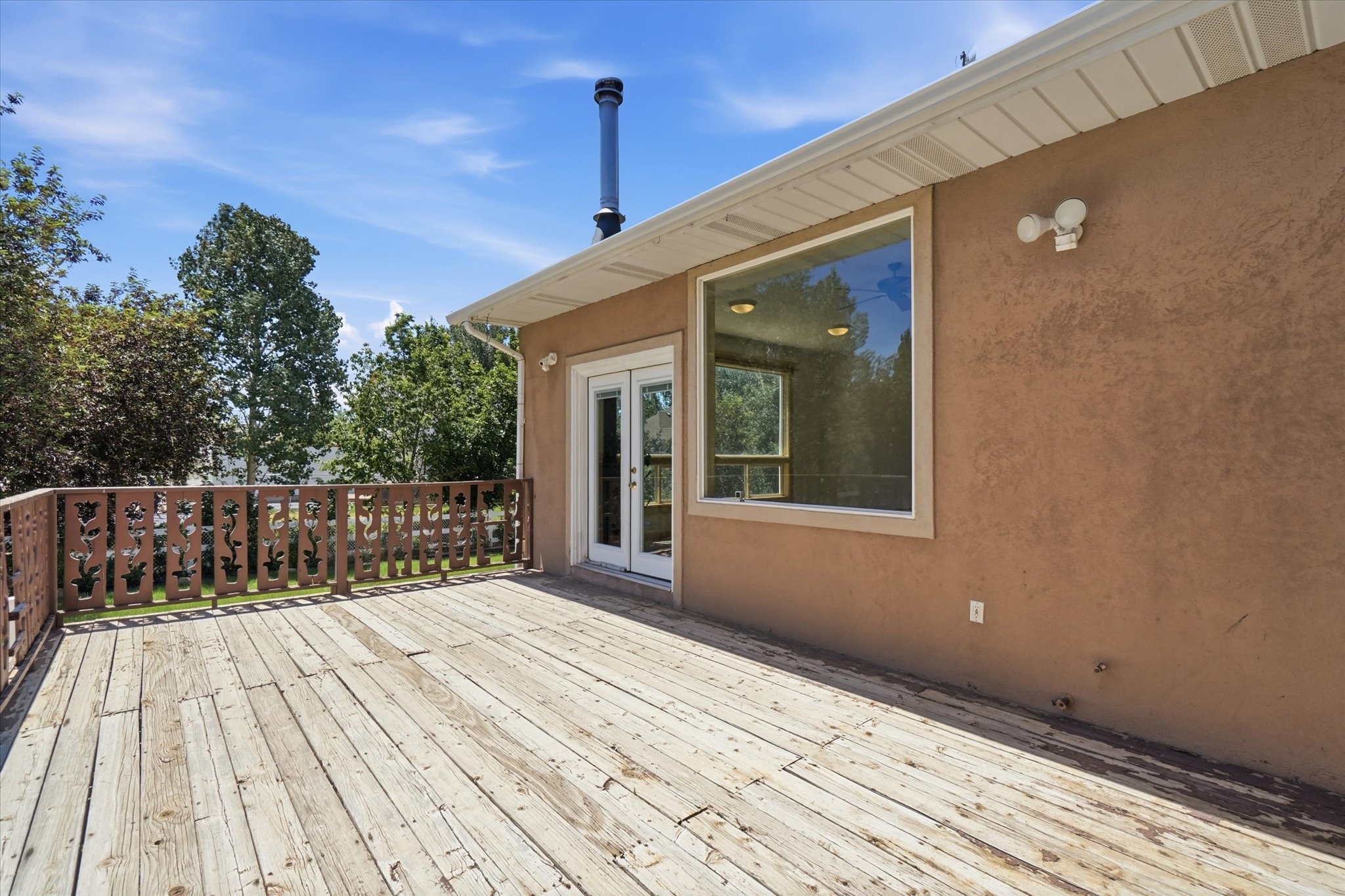 Expansive outdoor deck with wood-finish flooring and decorative railing