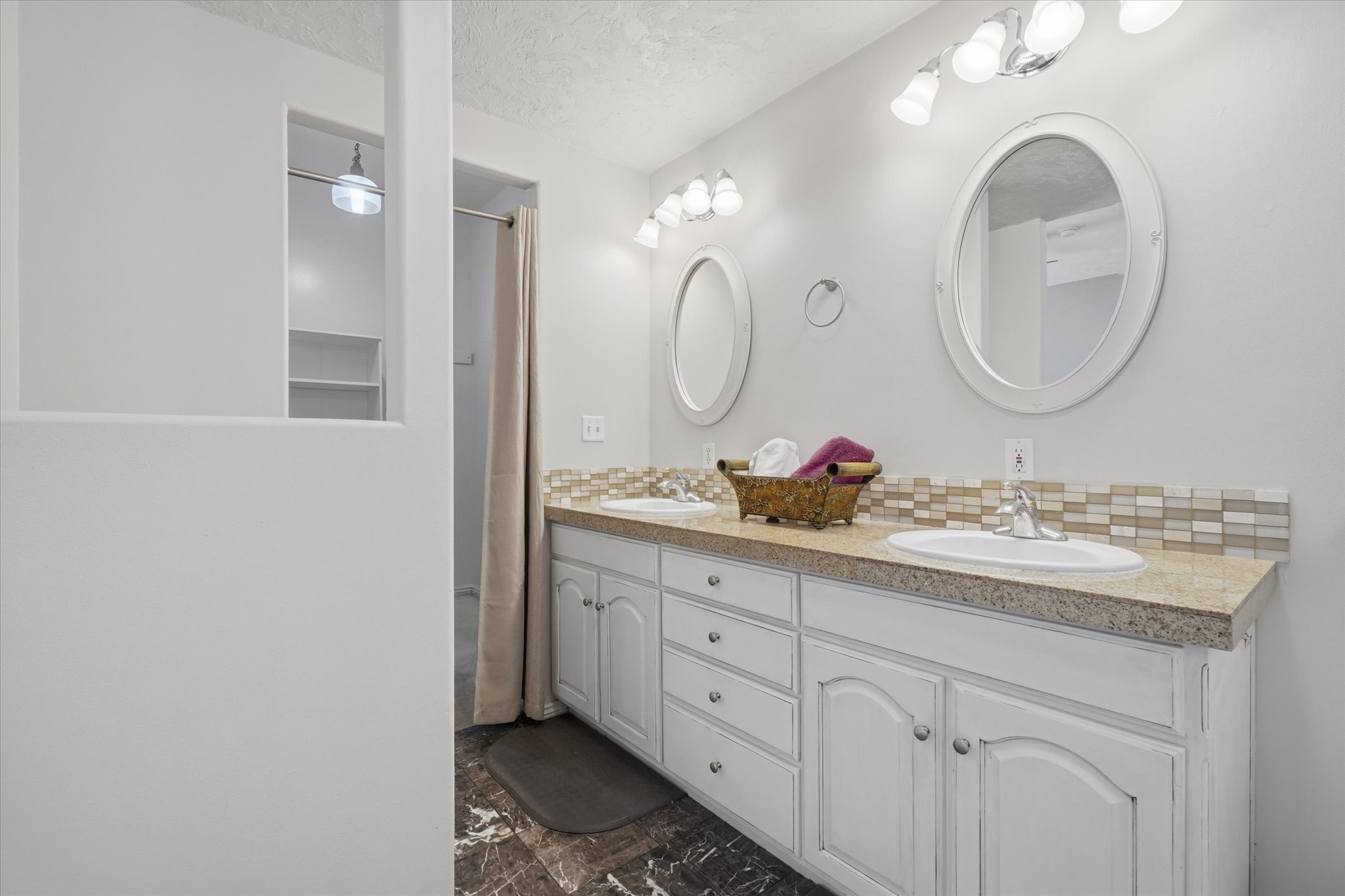 Dual vanity with white cabinetry, integrated sinks, and polished chrome faucets