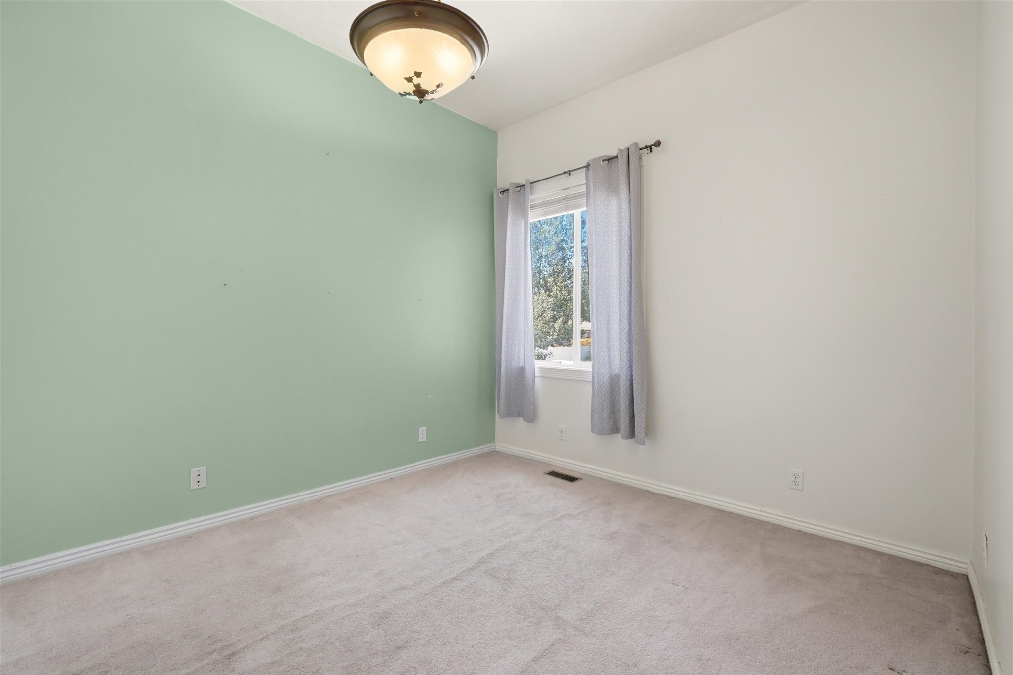 Interior room with vaulted ceilings and light green accent wall