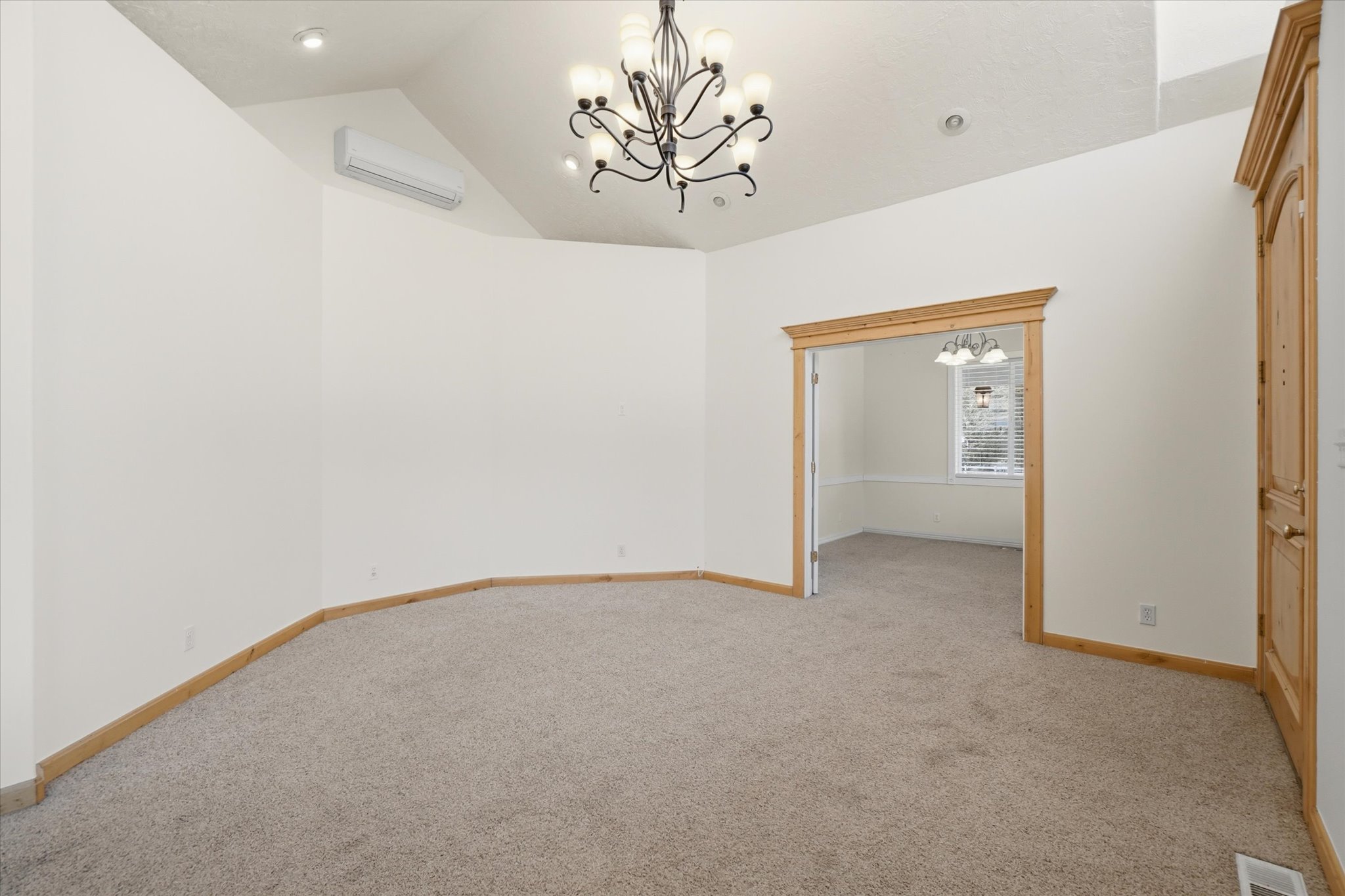 Spacious interior area featuring vaulted ceilings, recessed lighting, and a decorative chandelier