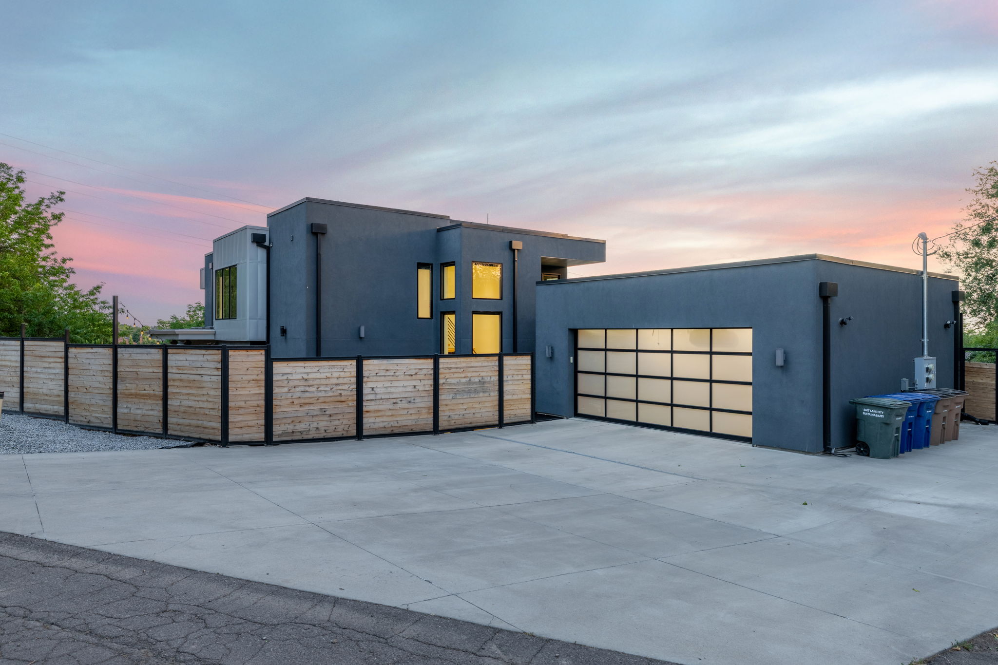 Modern architectural design featuring a smooth stucco exterior and a contemporary glass panel garage door