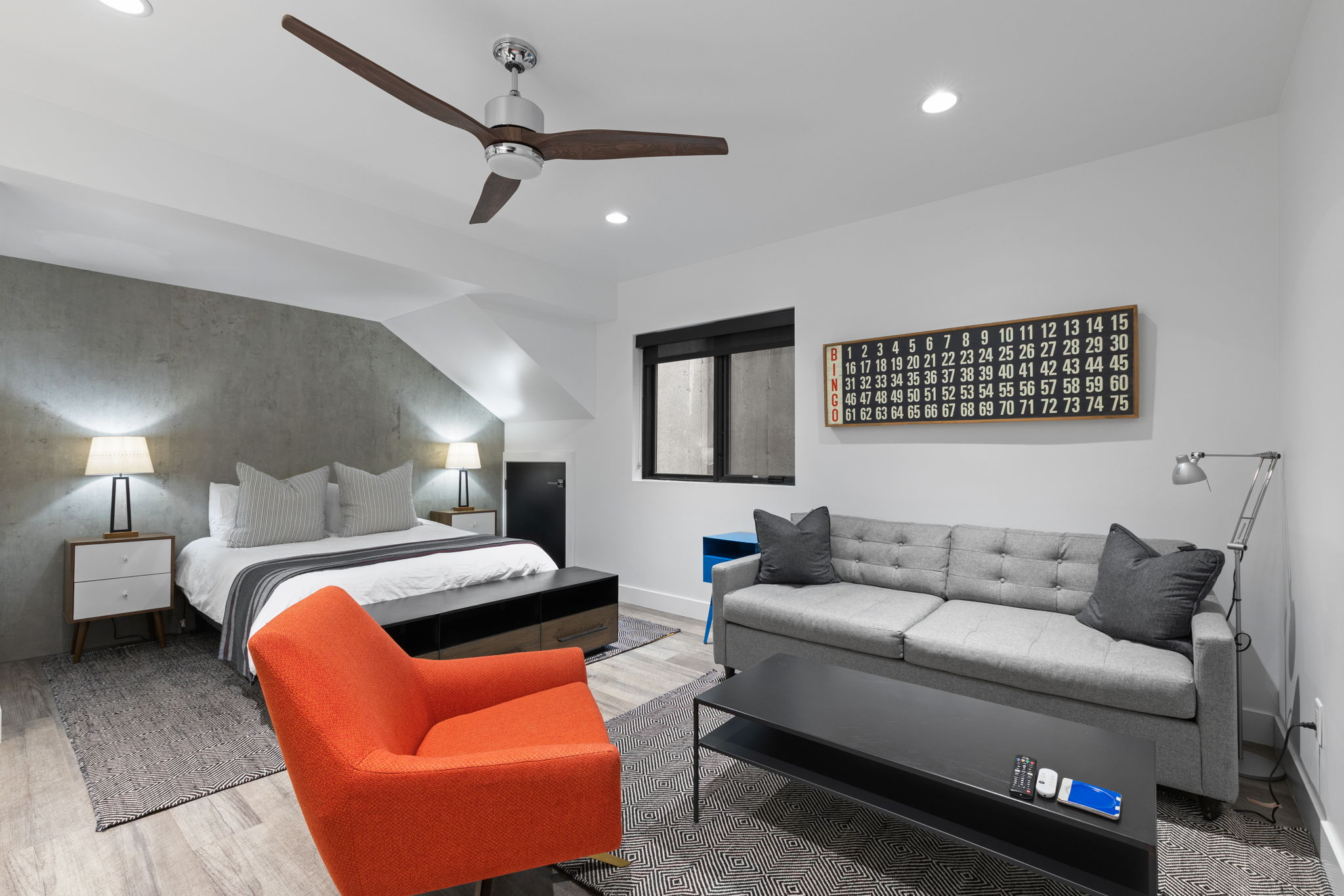 Versatile room featuring wood-finish flooring, a contemporary ceiling fan, recessed lighting, and a textured accent wall