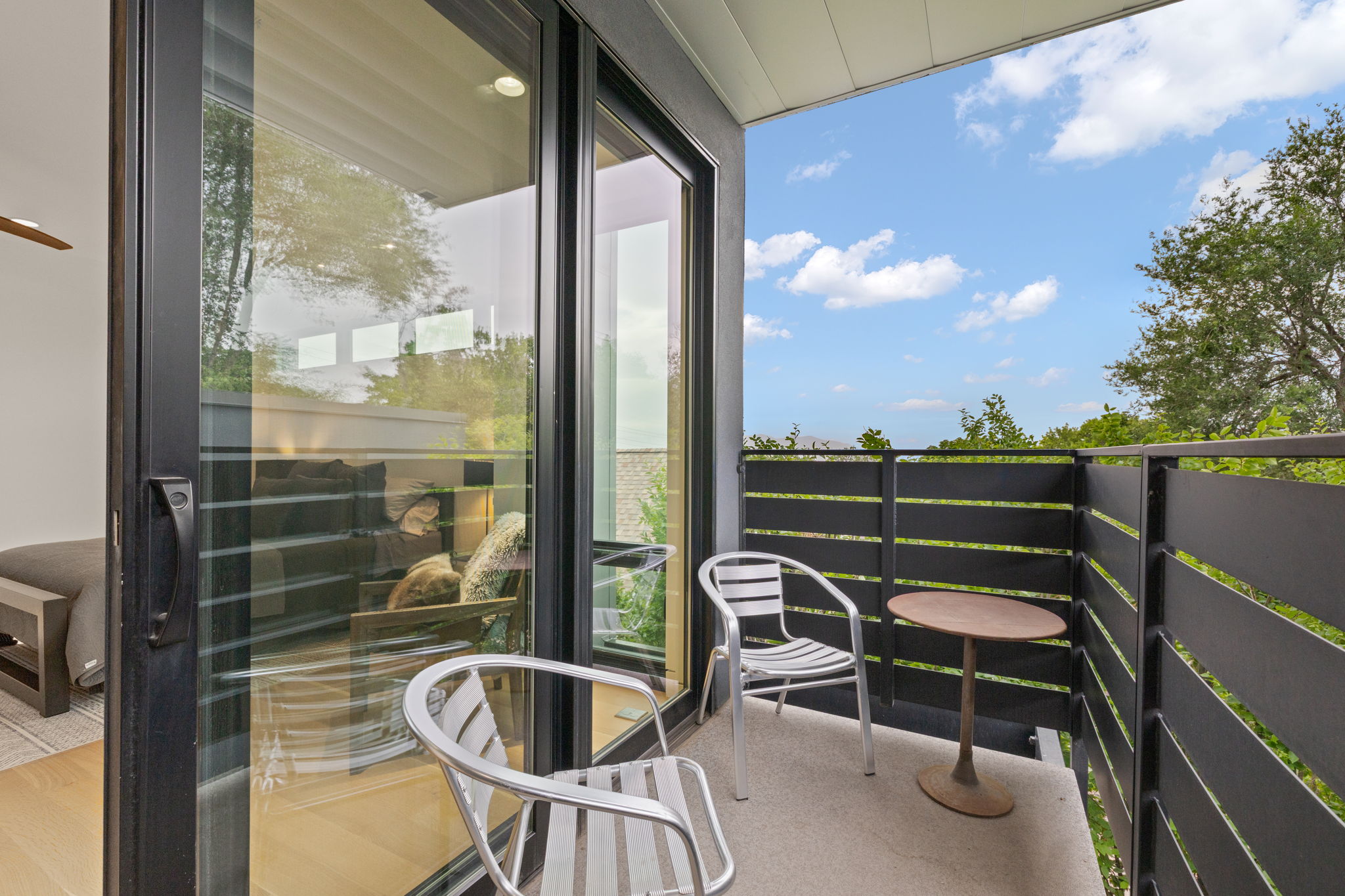 Private balcony featuring contemporary horizontal slat railings and concrete flooring