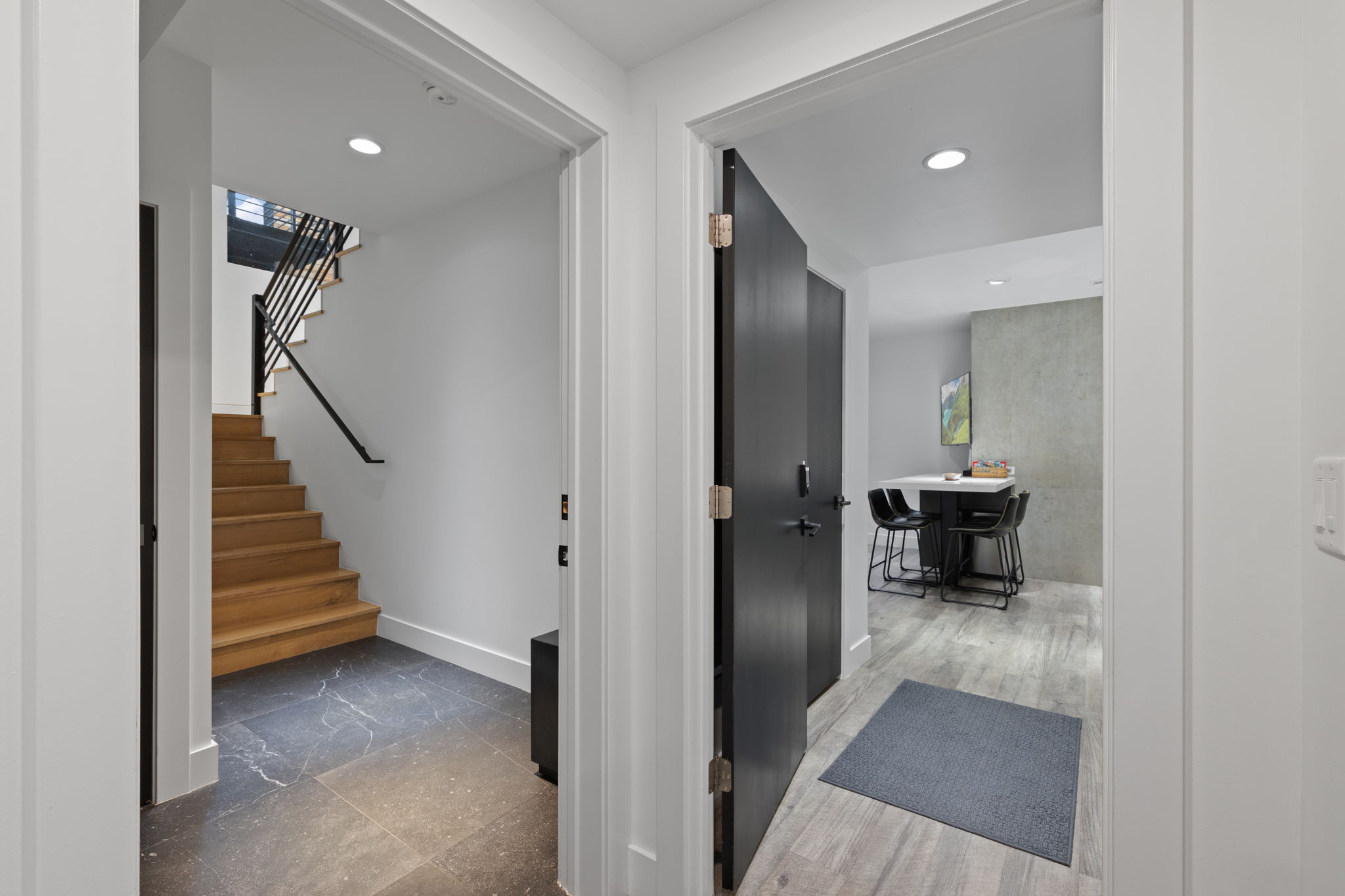 Modern interior featuring recessed lighting, light wood-finish flooring, and a dark wood-finish door