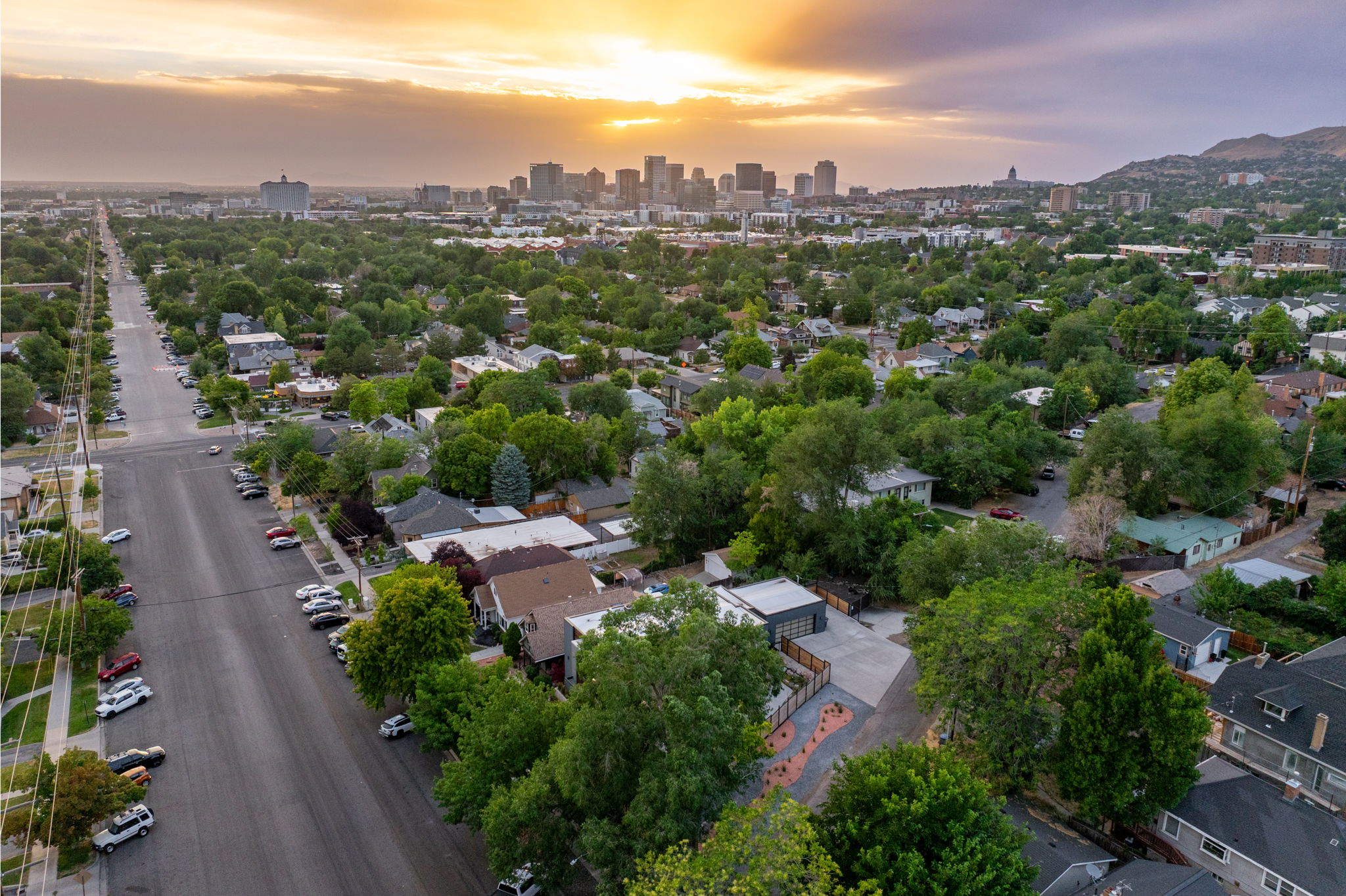Aerial perspective showcasing a residential neighborhood with a distant cityscape and mountain range