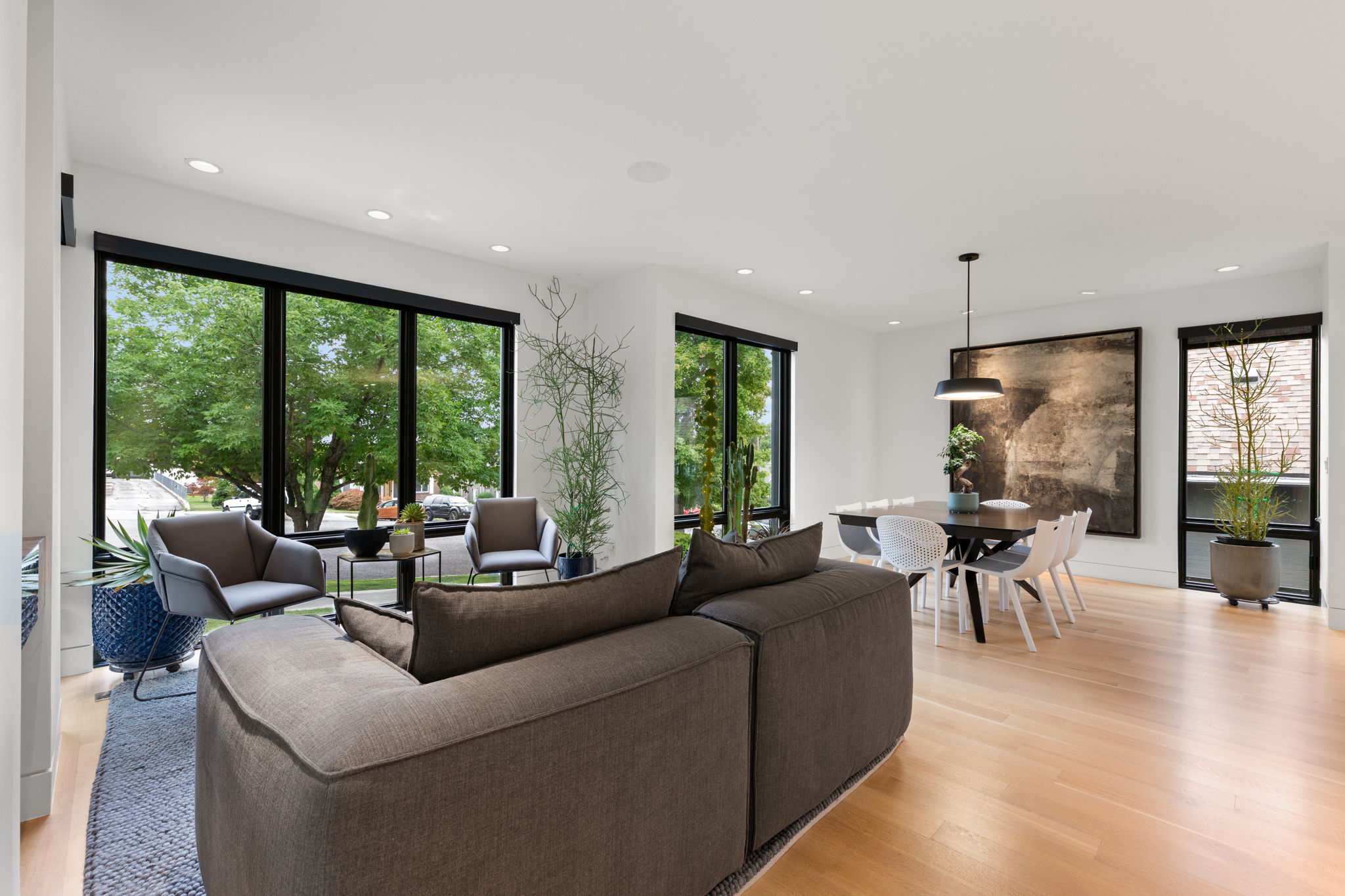 Open concept living space featuring light wood-finish flooring and extensive black-framed windows