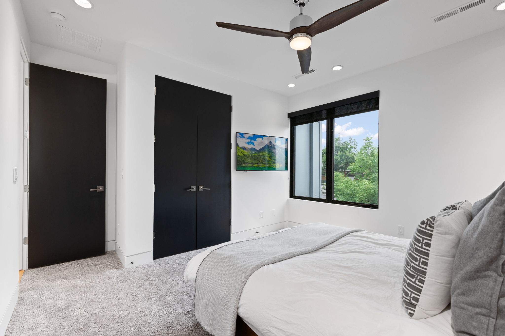Room featuring light gray carpeting, recessed lighting, and a modern ceiling fan