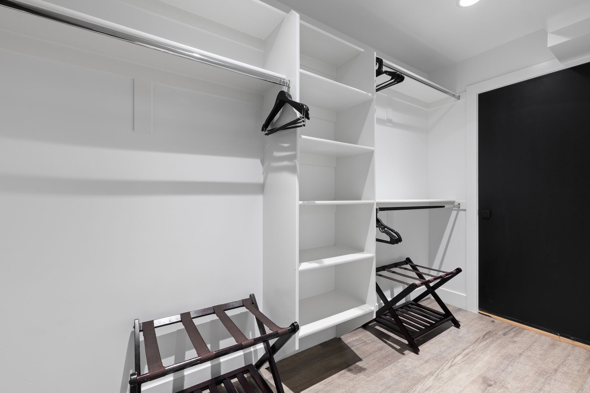 Organized closet system featuring multiple shelving units and hanging rods