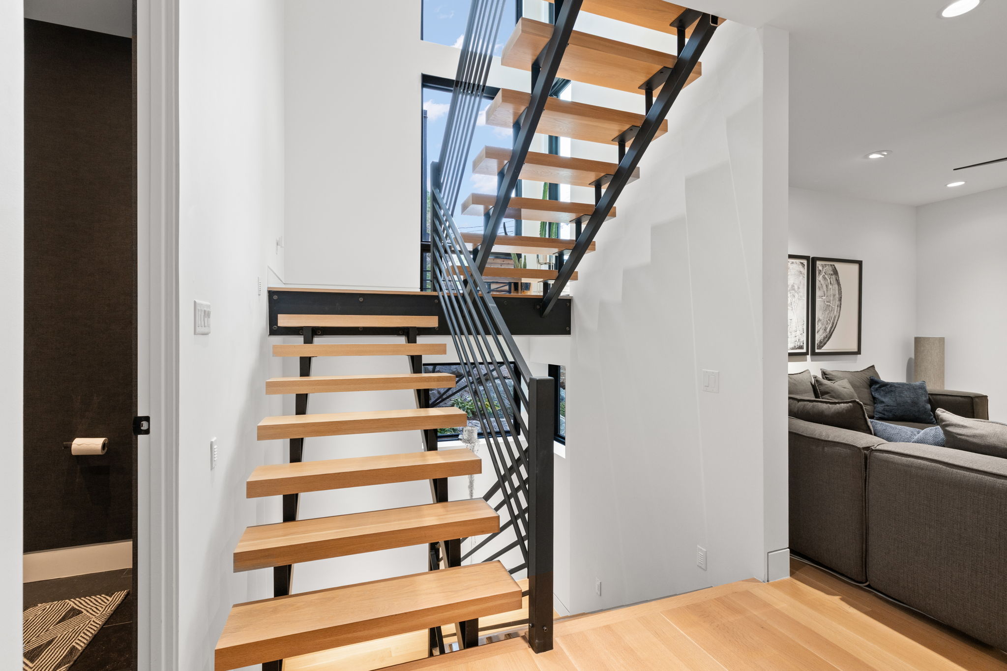 Contemporary open-riser staircase with wood-finish treads and metal railings