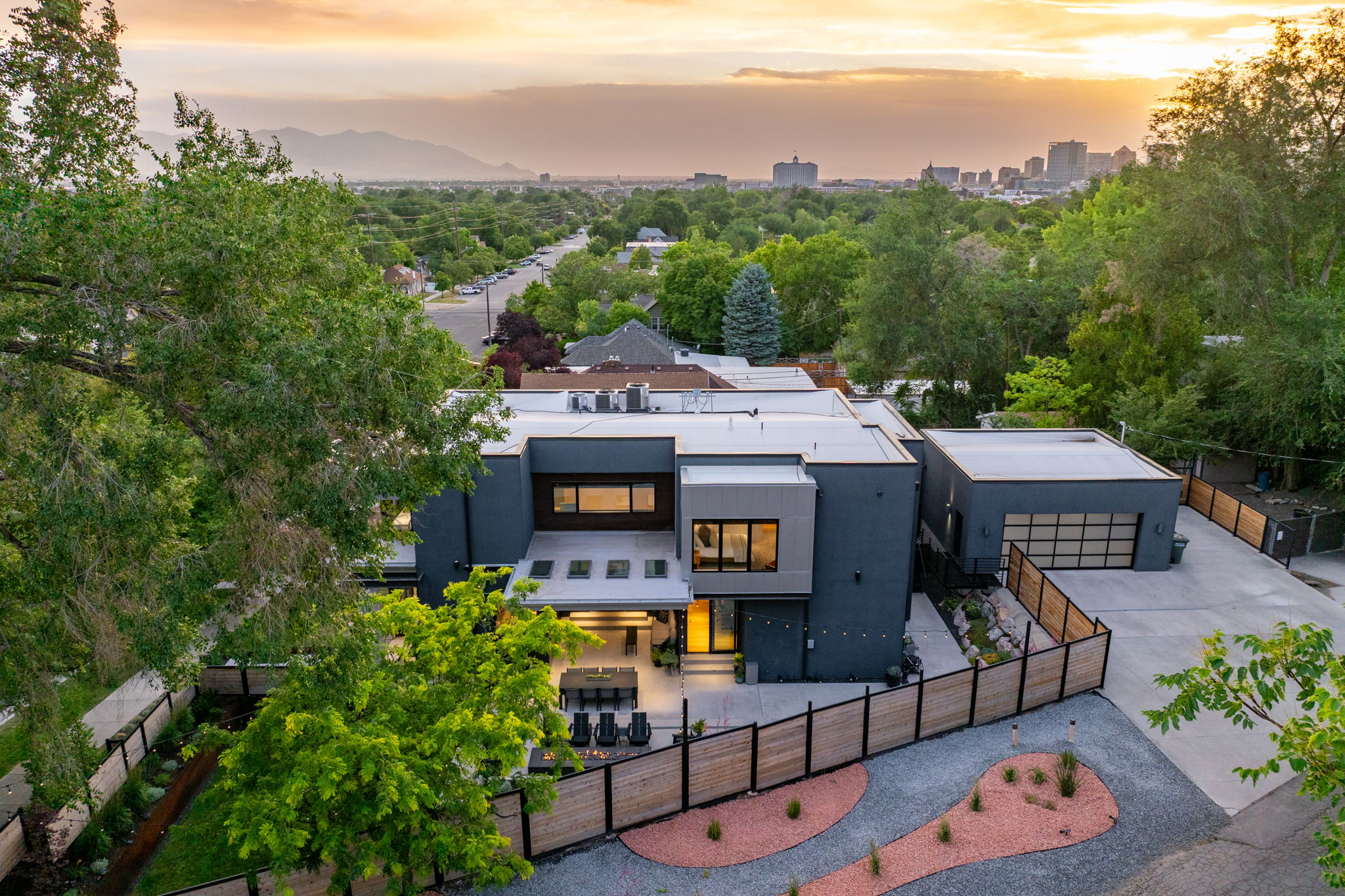 Modern architectural residence featuring a flat roofline, dark grey and light grey exterior panels, and extensive window placements