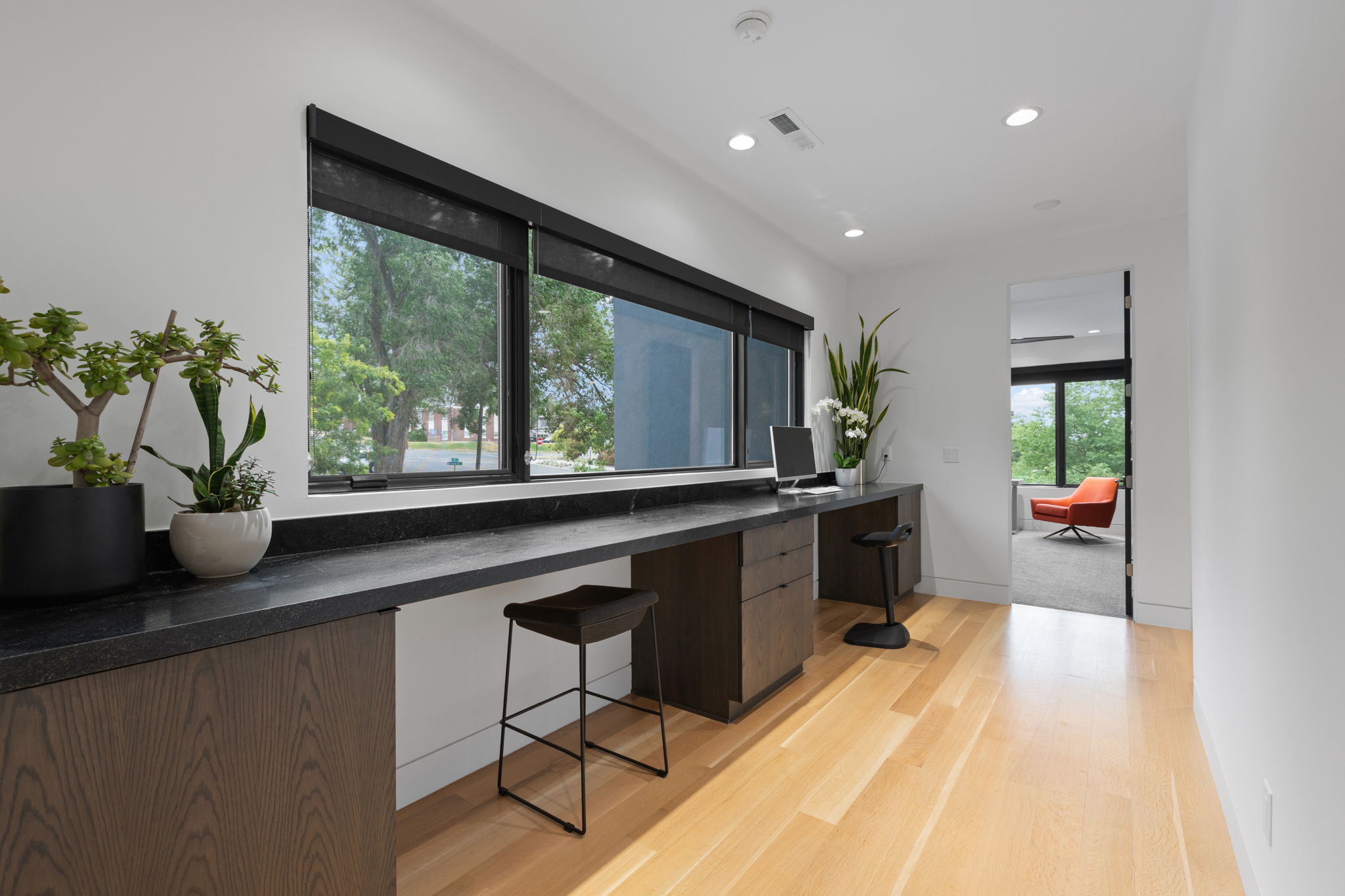 Workstation featuring wood-finish cabinetry, dark countertops, and expansive windows