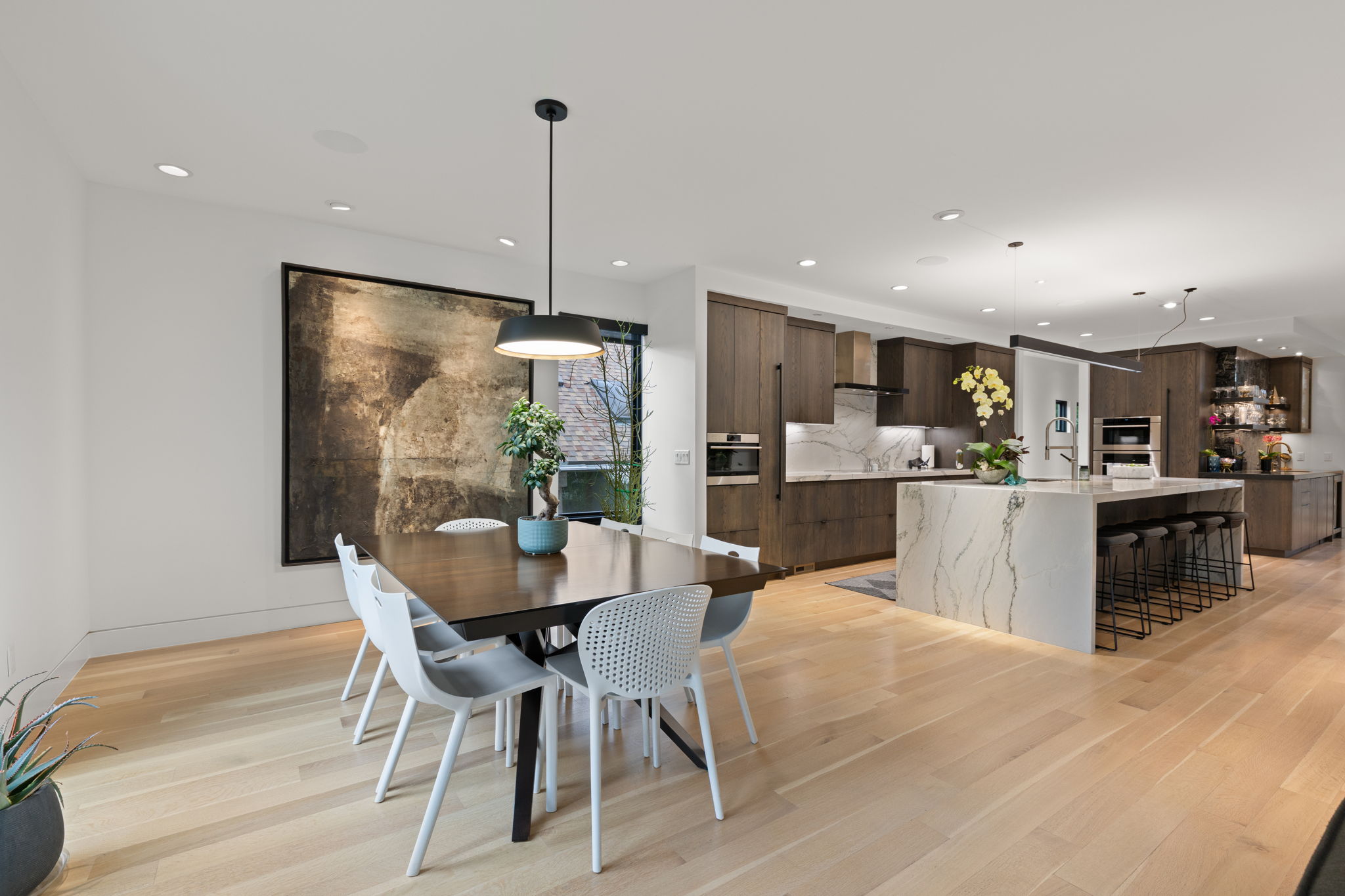 Open-concept kitchen and dining area featuring light wood-finish flooring