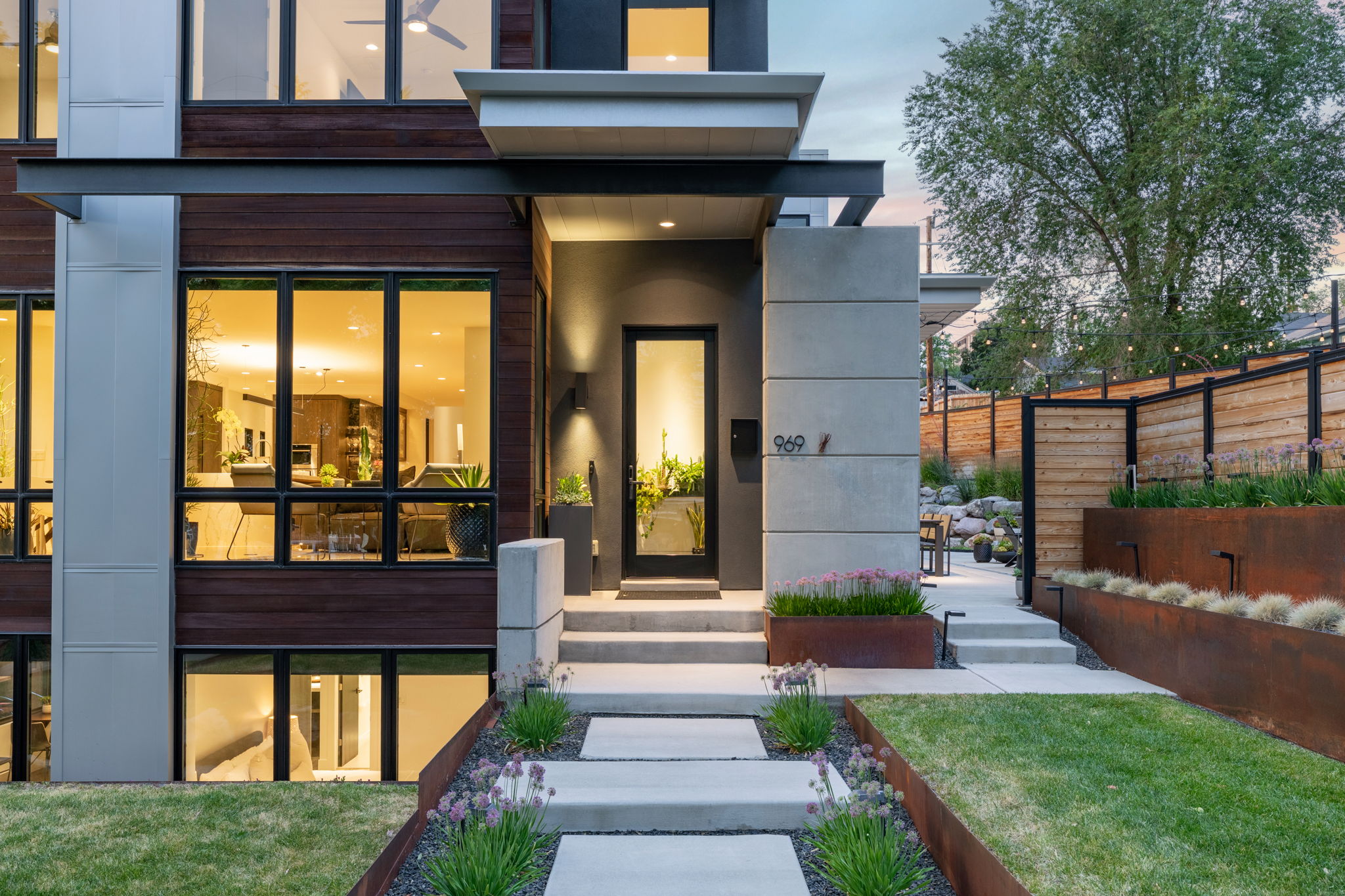 Modern facade featuring dark wood-look siding and large black-framed windows